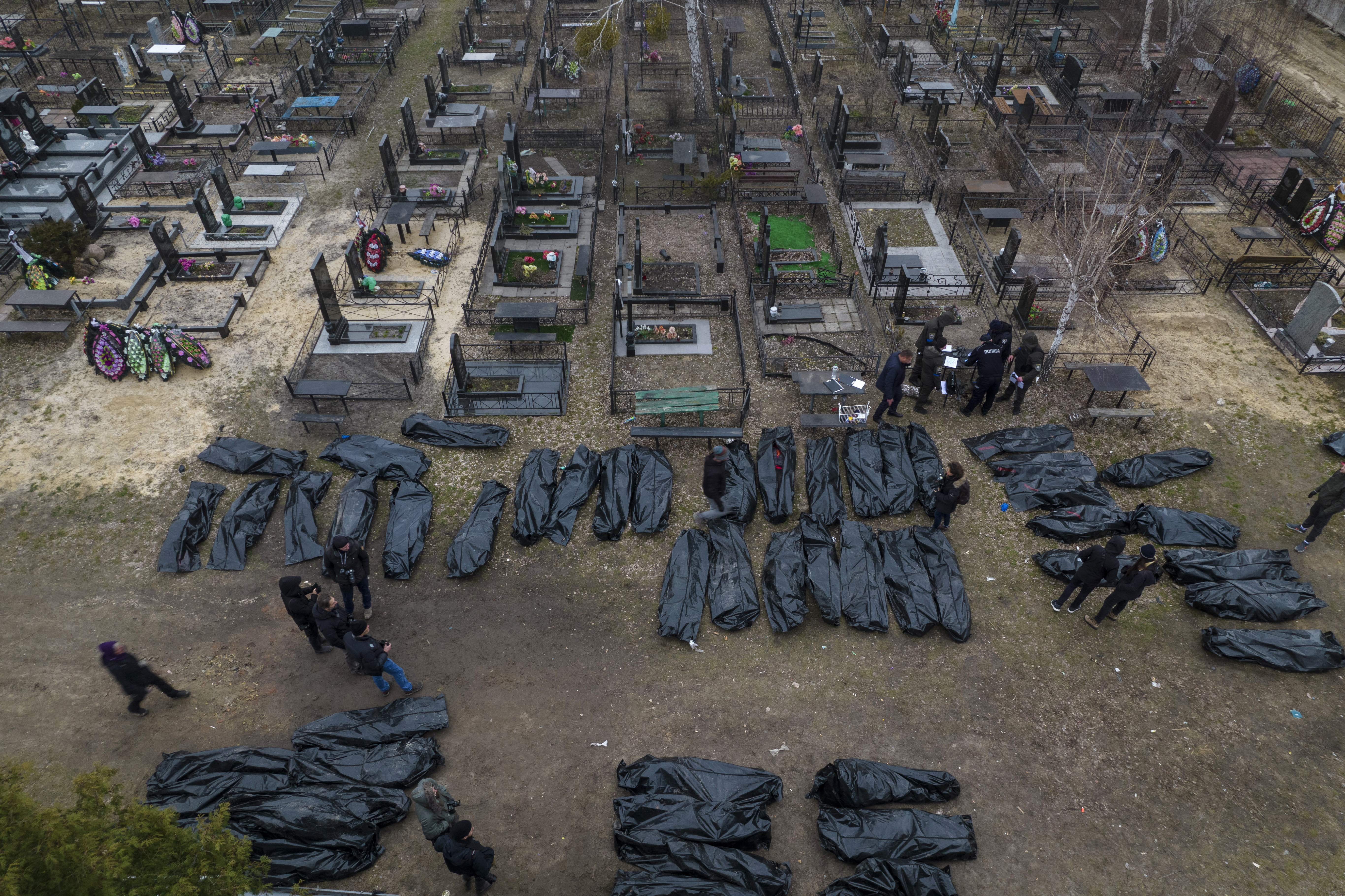 Police work on IDing civilians following killings in Bucha, before sending the bodies to the morgue, April 6, 2022. (Rodrigo Abd/AP)