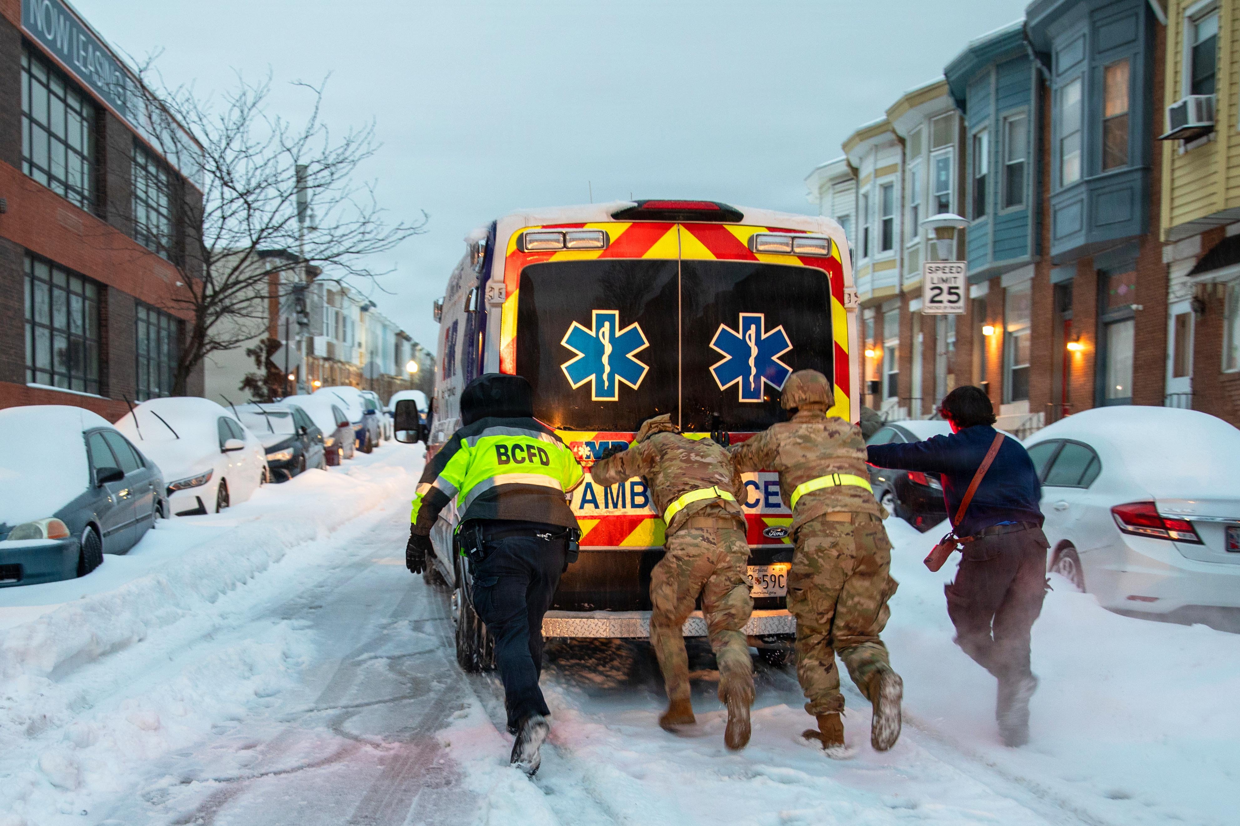 Maryland Army National Guard Soldiers from 1st Battalion, 175th Infantry Battalion and paramedics from Old Town Fire Station push an ambulance out of the snow in Baltimore, MD, January 25, 2026. At the direction of Governor Wes Moore, approximately 160 personnel of the Maryland National Guard activated to support civil authorities with specialized vehicles across the state to ensure rapid response capabilities for communities that may require assistance during inclement weather conditions. (U.S. Army National Guard photo by Staff Sgt. Lindiwe Henry).
