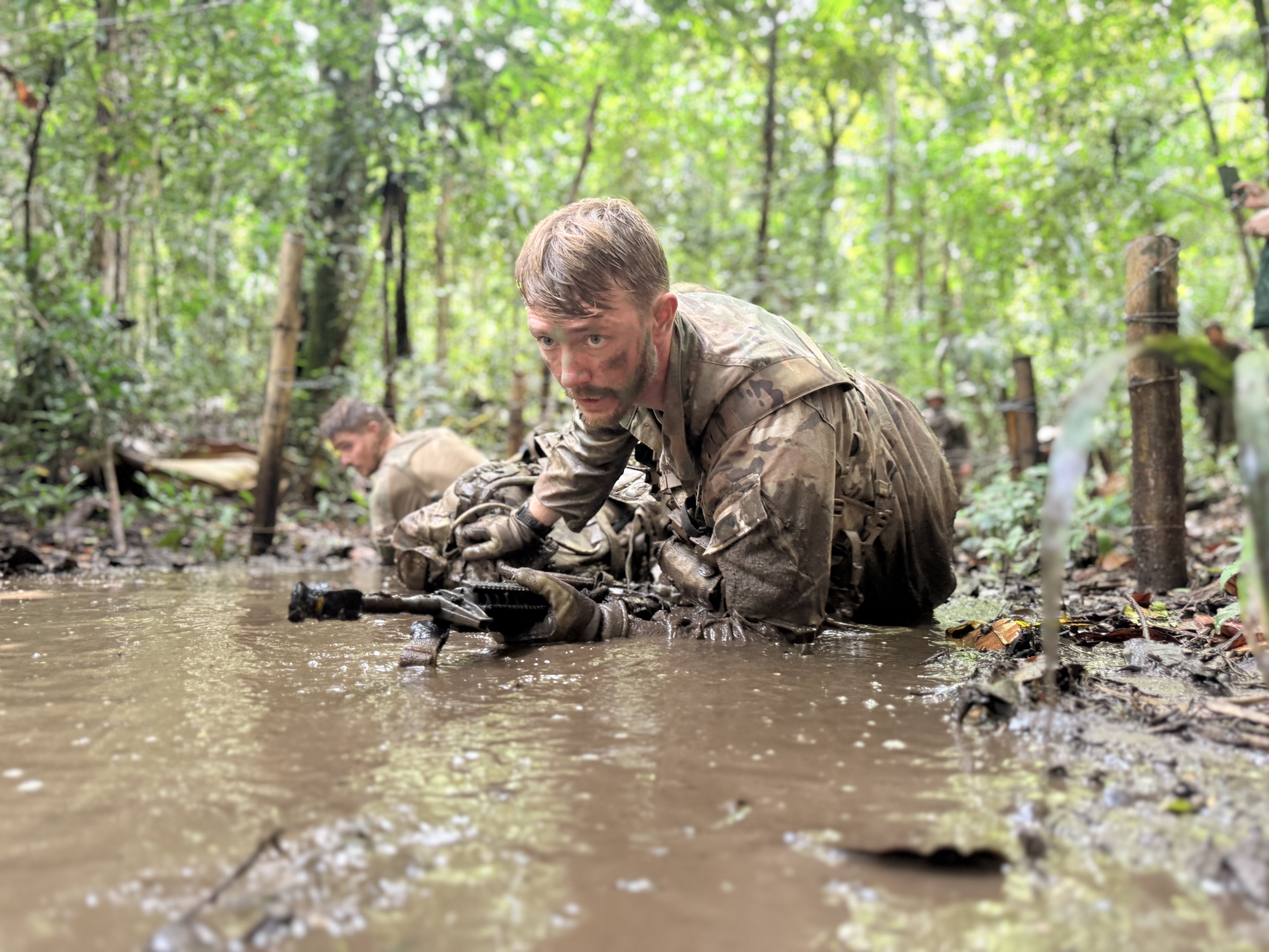 Participants in the U.S. Army's jungle school in Panama slog through mud during the course's culminating event, the Green Mile. (Eve Sampson/staff)