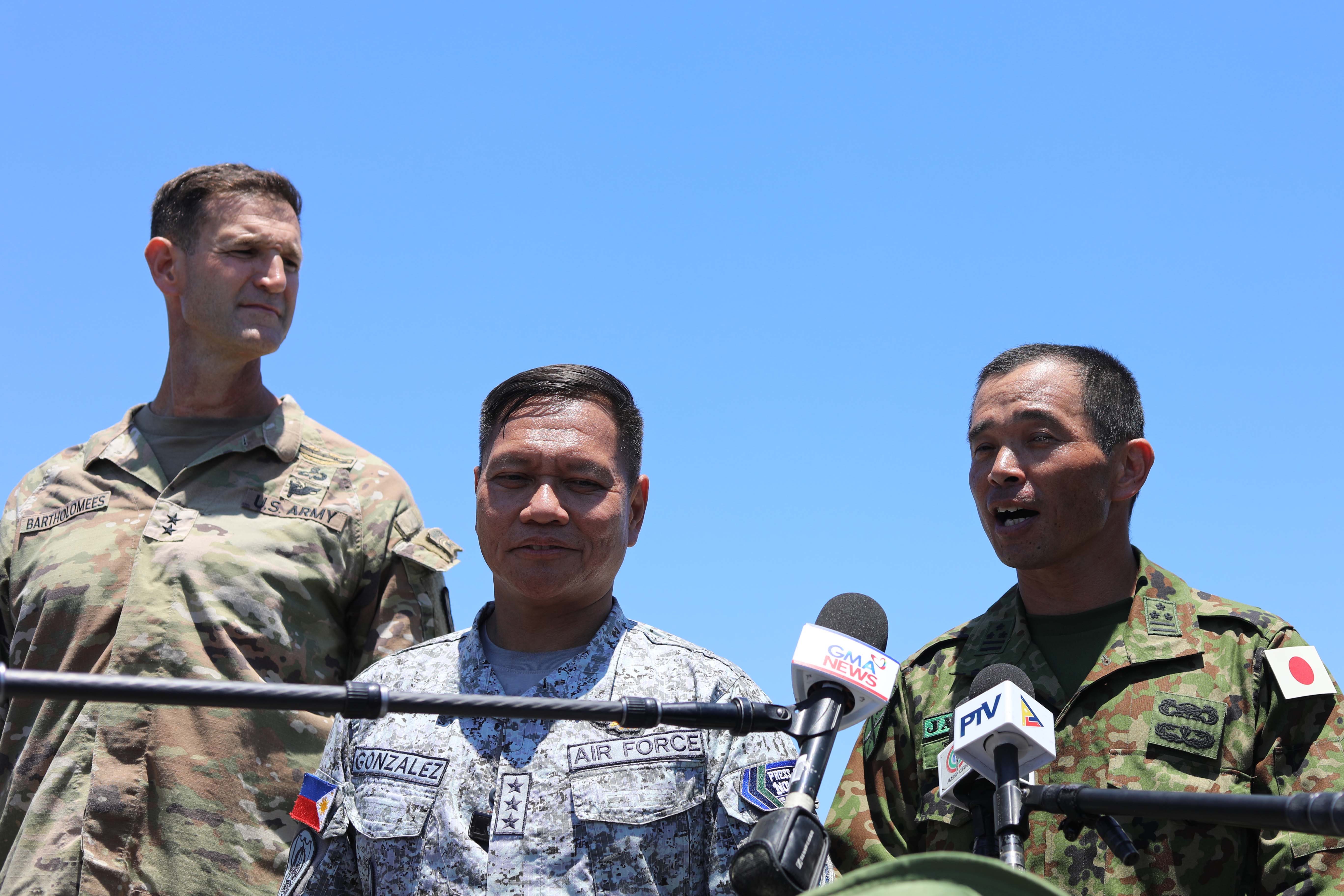 Maj. Gen. James Bartholomees (left), the U.S: Army 25th Infantry Division’s commanding general, addresses media on a beach alongside Philippine and Japanese colleagues during the Balikatan exercise in the Philippines in May 2026. (Gordon Arthur/staff)