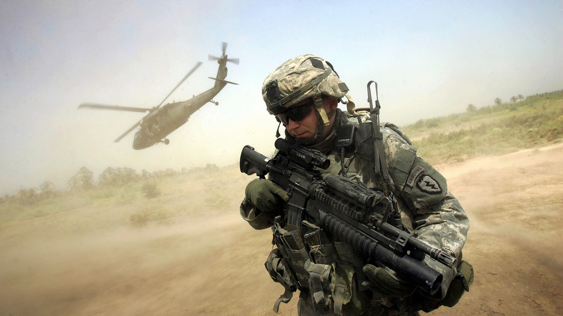 US Army soldier with rifle near UH-60 Black Hawk helicopter in Iraq