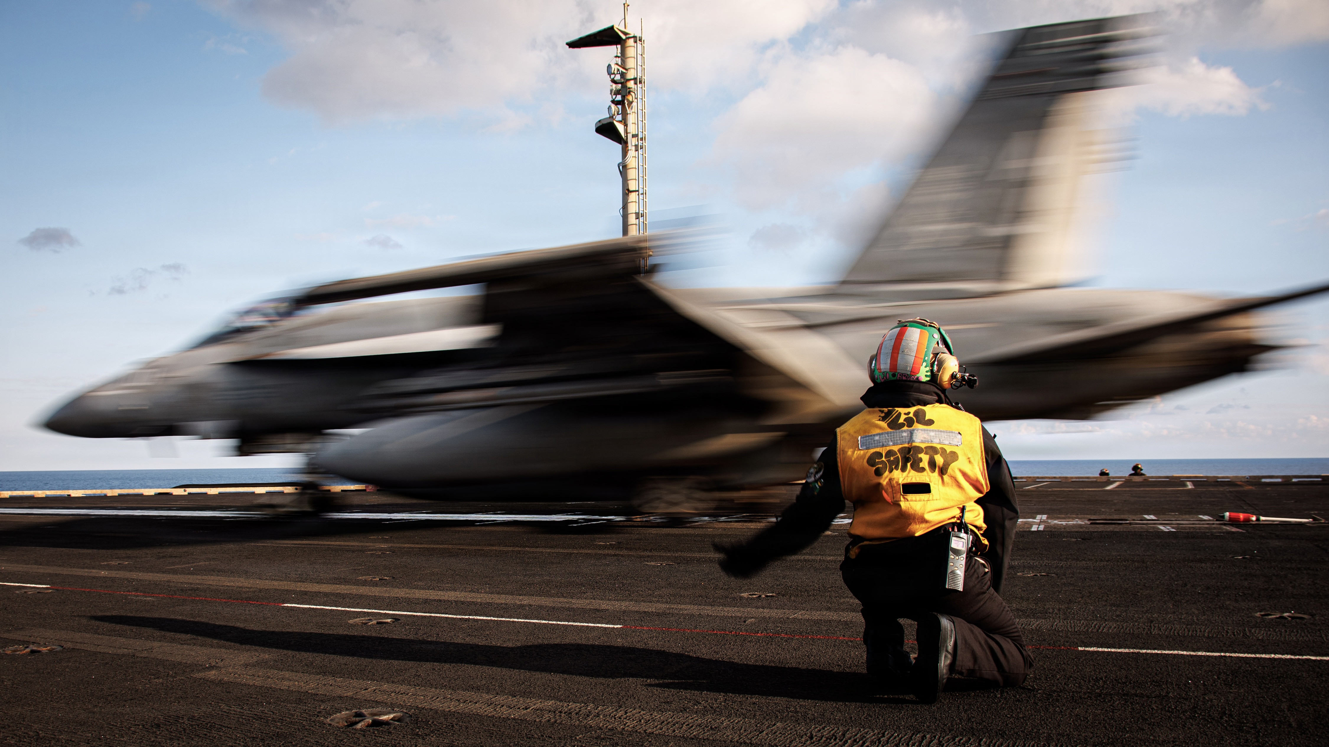 A U.S. sailor signals the launch of an F/A-18E Super Hornet from the flight deck of the USS Gerald R. Ford, March 2, 2026. (U.S. Navy)