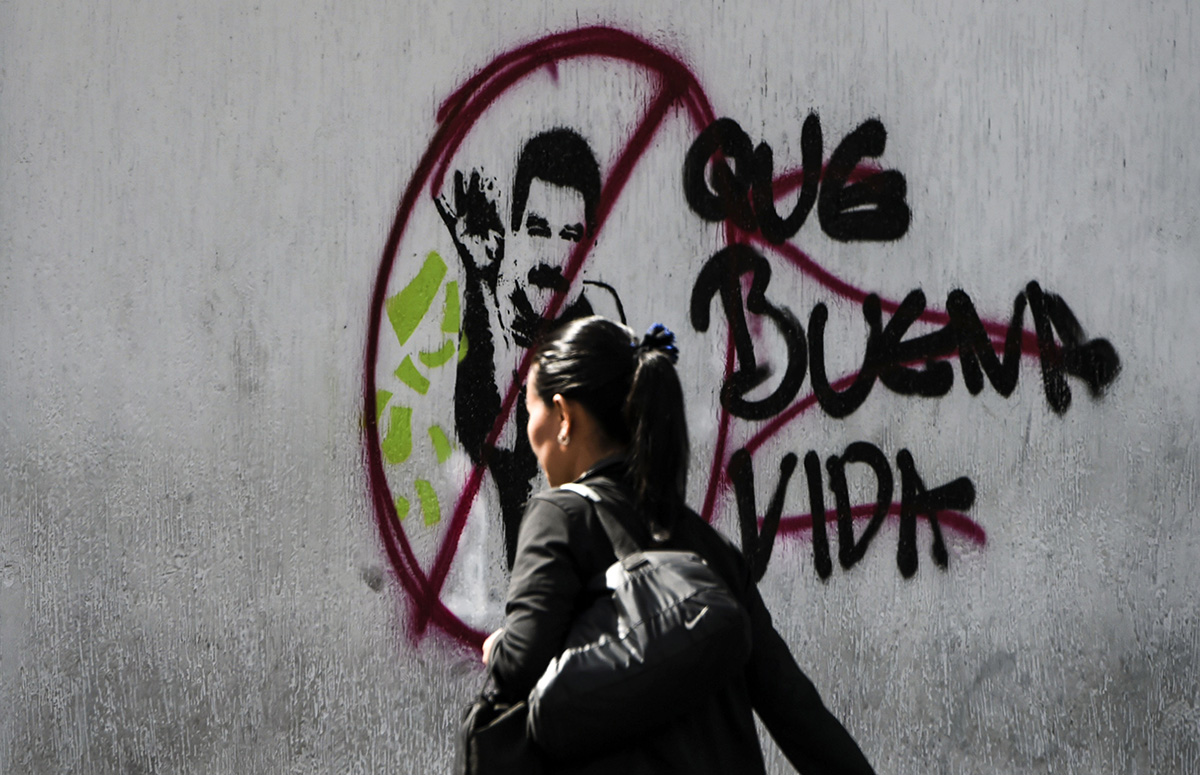 A woman walks past graffiti against Venezuelan President Nicolas Maduro in Caracas on Feb. 6, 2019. (Juan Barreto/AFP via Getty Images)