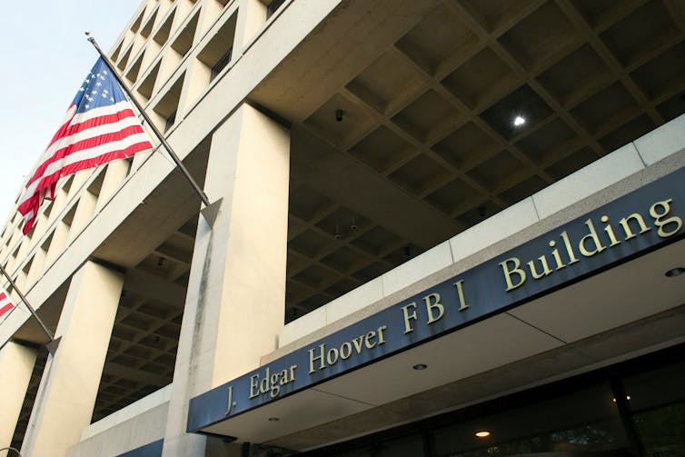 Exterior view of a federal building with an American flag flying on a mast.