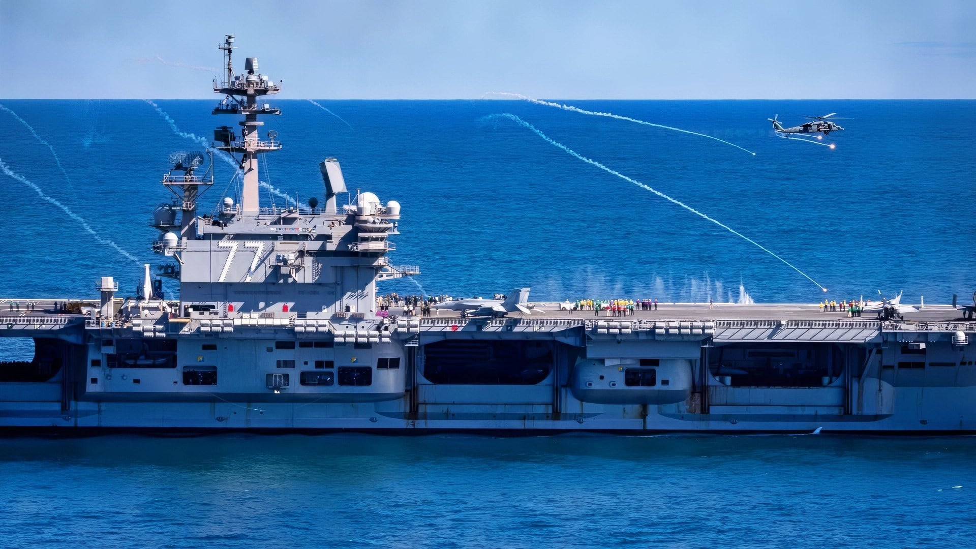 (Oct. 5, 2025) An MH-60S Sea Hawk attached to the “Dusty Dogs” of the Helicopter Sea Combat Squadron (HSC) 7 fires flares above the Nimitz-class aircraft carrier USS George H.W. Bush (CVN 77) in support of the Titans at Sea Presidential Review. The Titans of the Sea Presidential Review is one of many events taking place throughout the country to showcase maritime capabilities as part of the U.S Navy’s 250th birthday. America is a maritime nation. For 250 years, America’s Warfighting Navy has sailed the globe in defense of freedom. (U.S. Navy photo by Mass Communication Specialist 2nd Class Mitchell Mason)