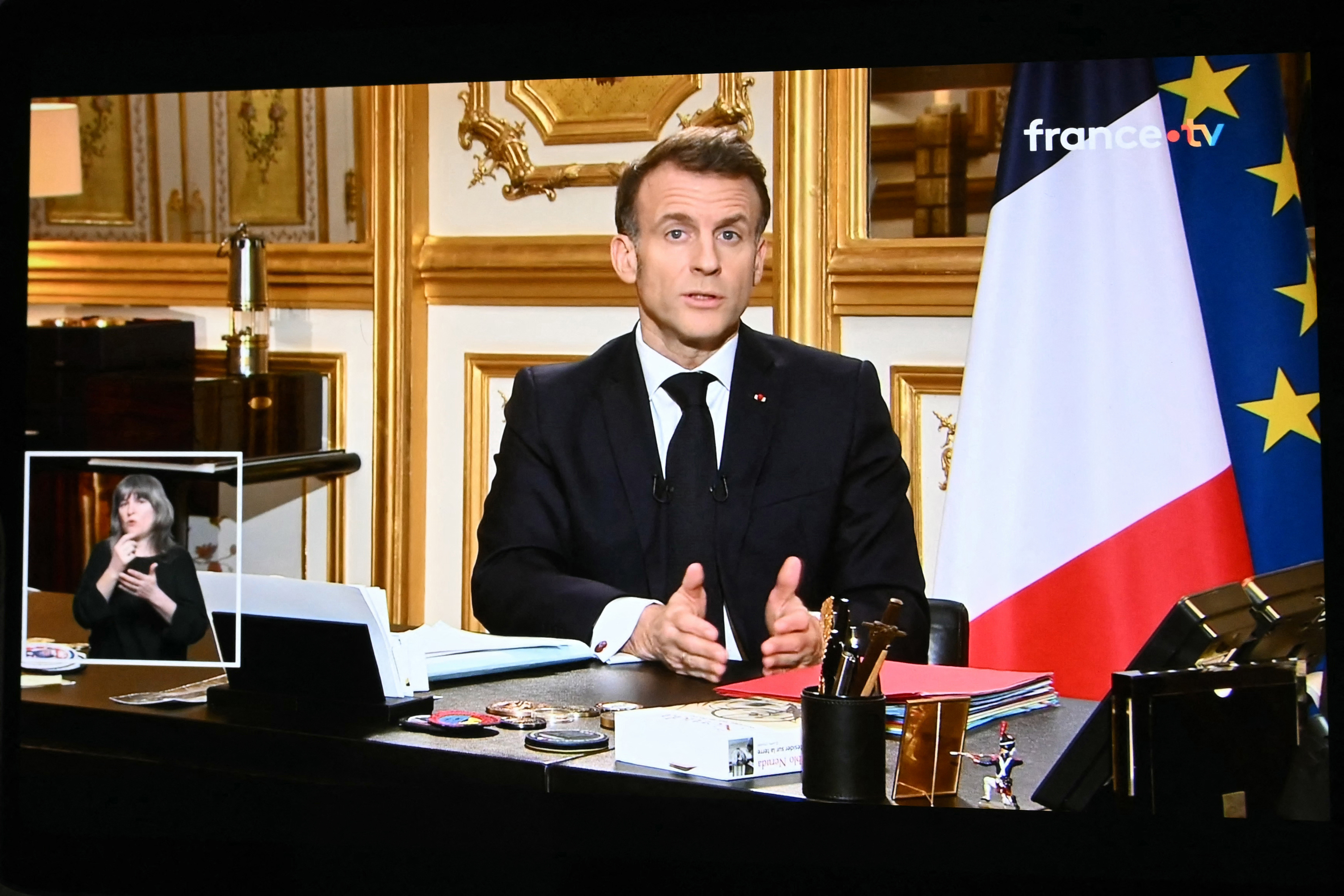 This photograph shows screens broadcasting French President Emmanuel Macron's address on the war in Iran and its repercussions on the Middle East, from the Elysee Palace in Paris on March 3, 2026. (Sebastien Bozon / AFP via Getty Images)