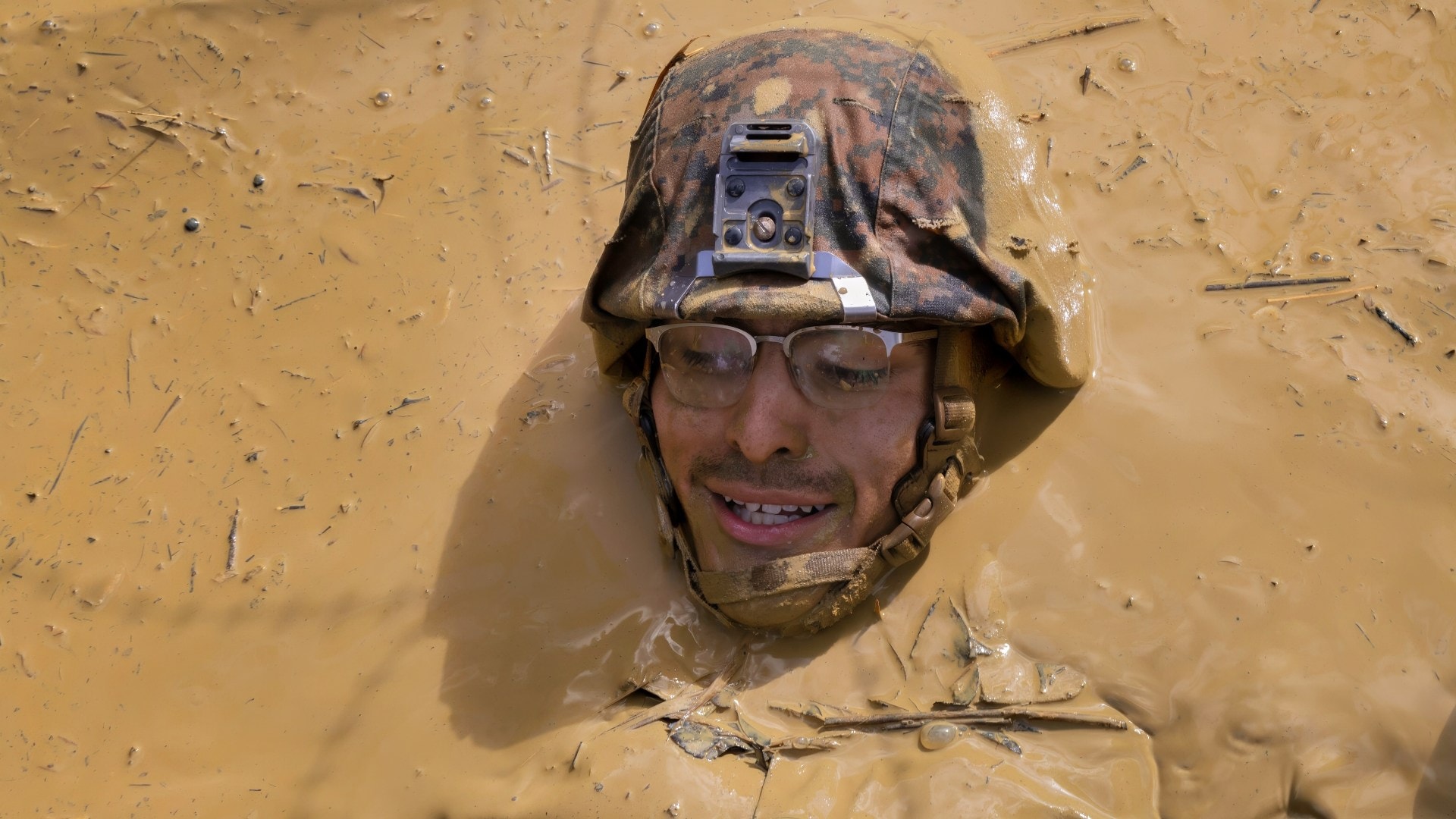 A U.S. Marine with 9th Engineer Support Battalion (9th ESB), 3rd Marine Logistics Group, crawls through mud during the final obstacle of the endurance course as a part of the Basic Jungle Skills Course (BJSC) at Jungle Warfare Training Center, Camp Gonsalves, Okinawa, Japan, Dec. 15, 2023. The training taught Marines to successfully navigate through dense marsh and vegetation, rappel down steep cliffs, establish a patrol base and better their knowledge of patrolling and defensive operations. 9th ESB completed the BSJC to mentally and physically operate in harsh jungle environments. (U.S. Marine Corps photo by Lance Cpl. Aaliyah Hunt)
