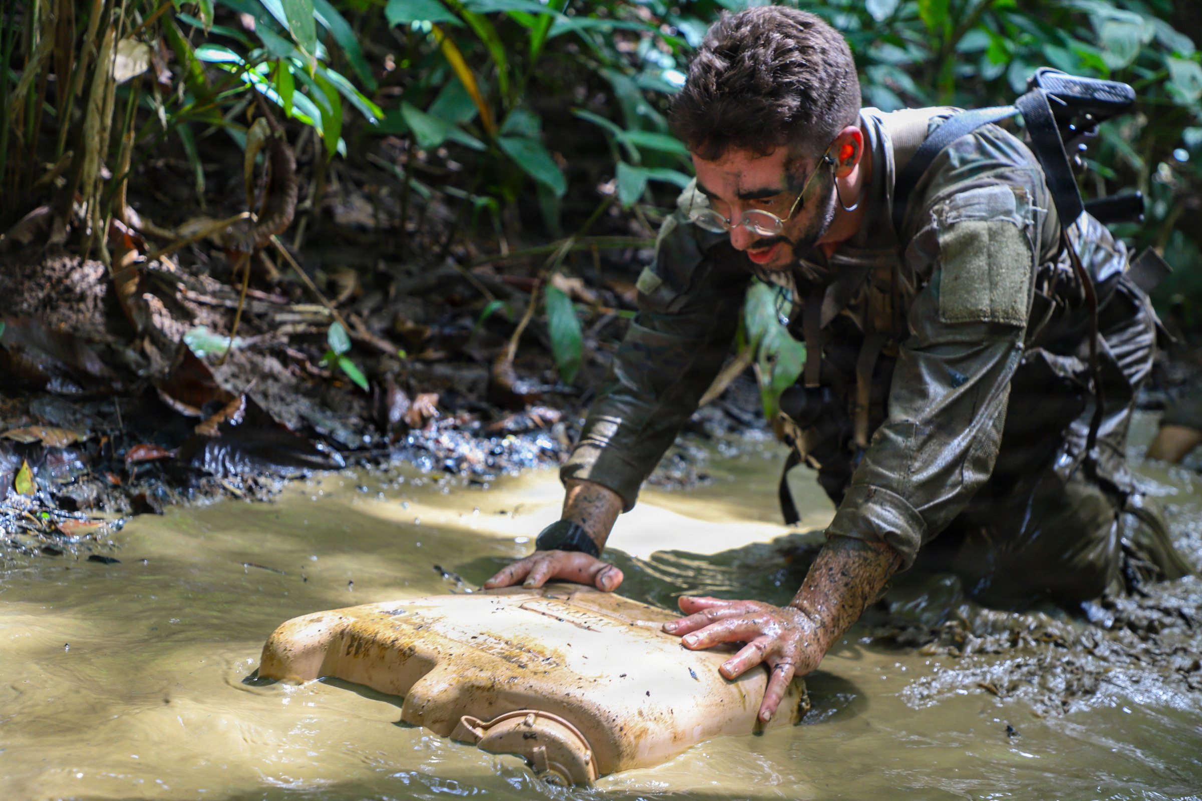 A candidate in the Jungle Operations Training Course-Panama crawls through a water obstacle during the Green Mile at Aeronaval Base Cristóbal Colón, Panamá, Aug. 1, 2026. (Pfc. Oshon Trowbridge/U.S. Army)