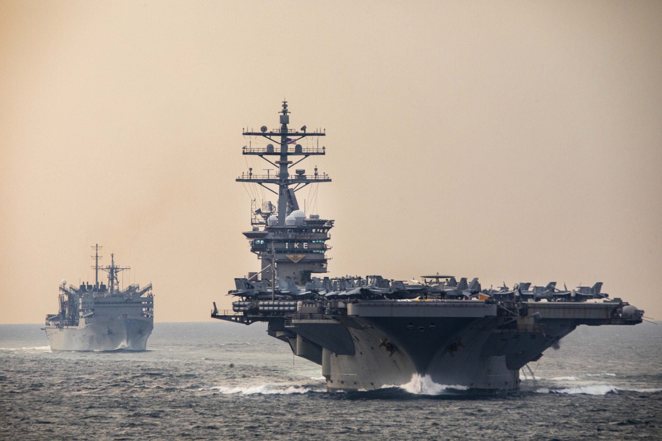 Components of the Dwight D. Eisenhower Strike Group (IKECSG) and the fast combat support ship USNS Supply (T-AOE 6) transit the Strait of Hormuz, Dec 14, 2023. As part of the Dwight D. Eisenhower Carrier Strike Group (IKECSG), the Philippine Sea is deployed to the U.S. 5th Fleet area of operations to help ensure maritime security and stability in the Middle East region. (U.S. Navy photo by Mass Communication Specialist 2nd Class Keith Nowak)
