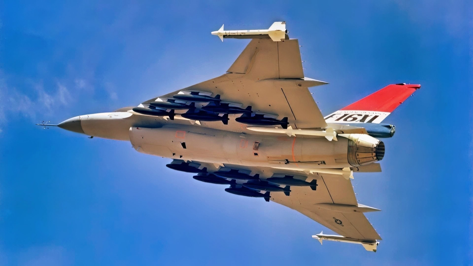 F-16XL飞机的空对空左下侧视图。该飞机装备有两个机翼尖挂载的AIM-9响尾蛇导弹和四个机身挂载的AIM-7海麻雀导弹，以及12枚500磅炸弹。