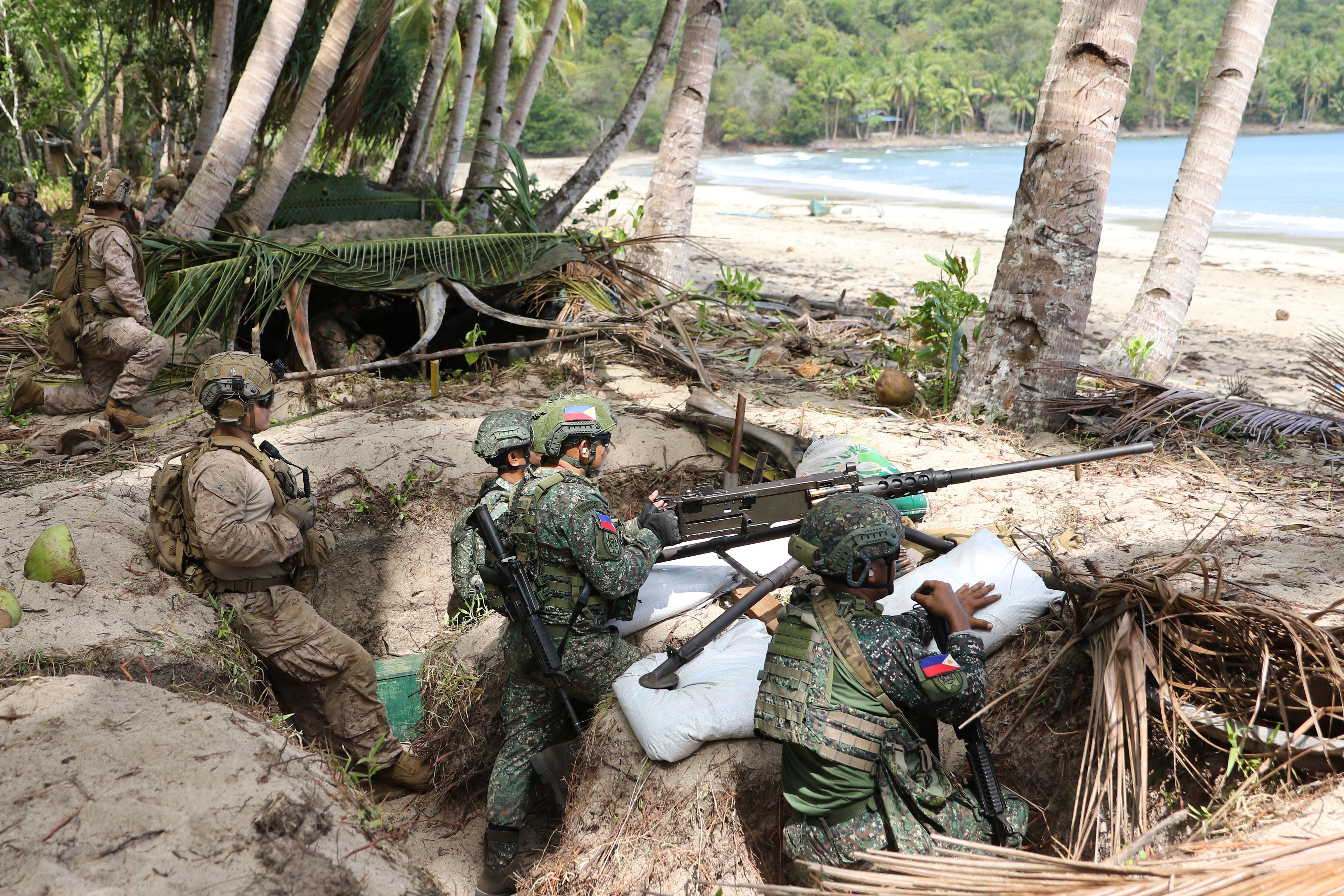 Philippine and American Marines hidden in foxholes await enemy landing forces on a pristine Palawan, Philippines, beach during the Balikatan 2026 exercise on April 27, 2026. (Gordon Arthur/staff)