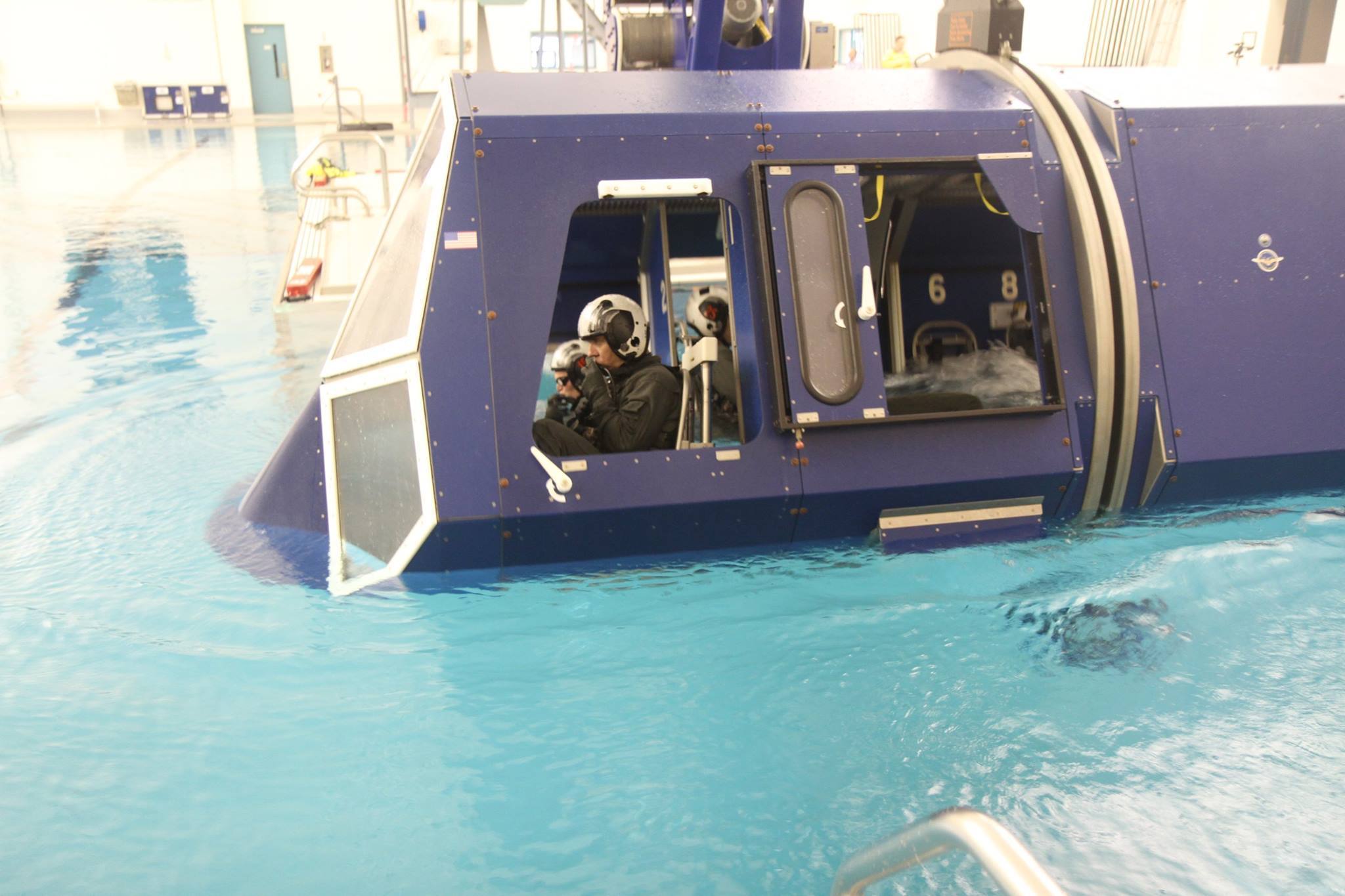 U.S. Army AH-64E Apache pilots submerge in a simulated aircraft as it begins to roll over during water survival training. (Brian Harris/U.S. Army)