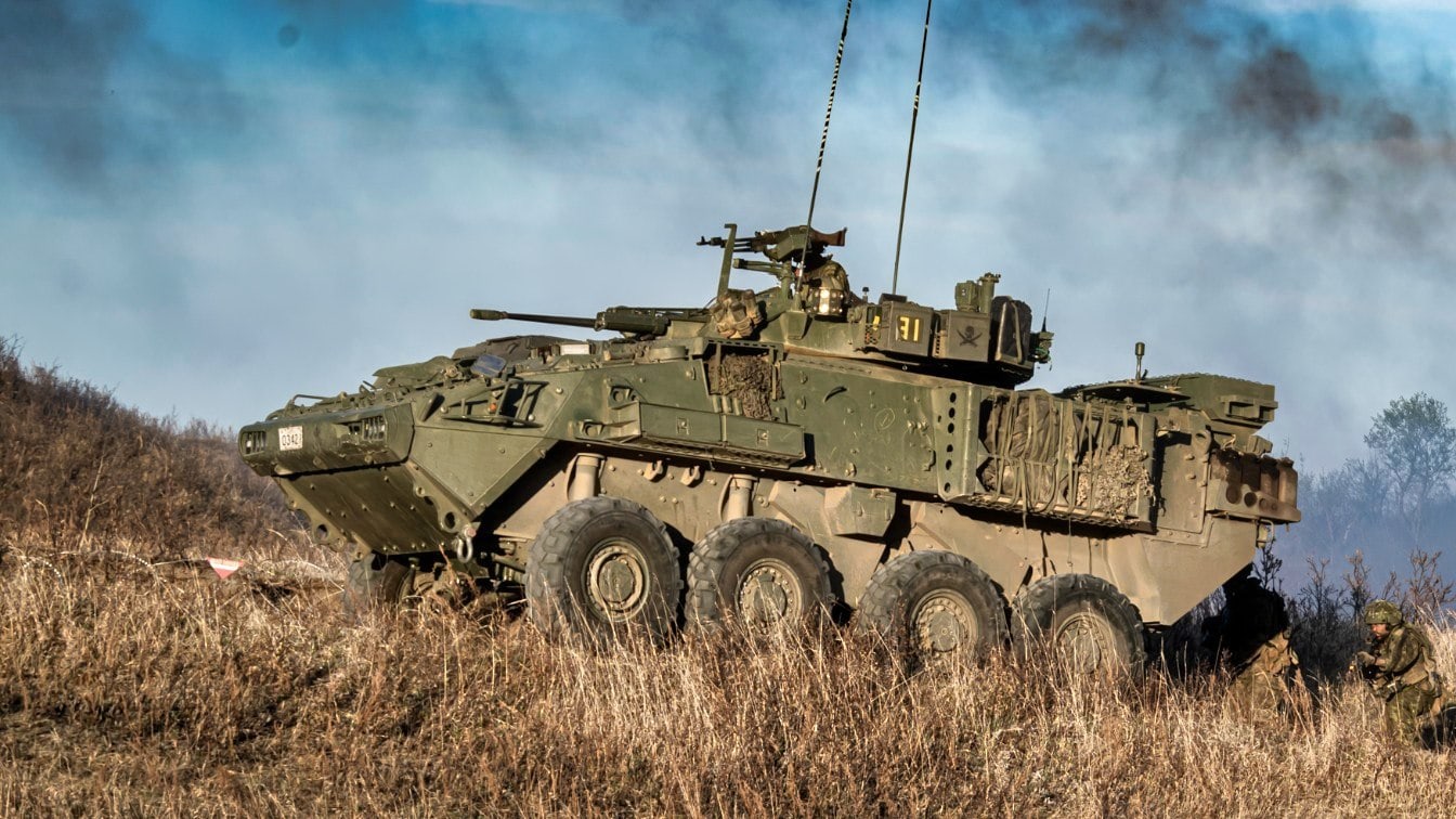 Members of 1st Battalion Princess Patricia’s Canadian Light infantry, playing as coalition forces take cover behind a Light Armored Vehicle (LAV) 6.0 during Ex MAPLE RESOLVE in Wainwright, Alberta on May 10th, 2021.<br />
