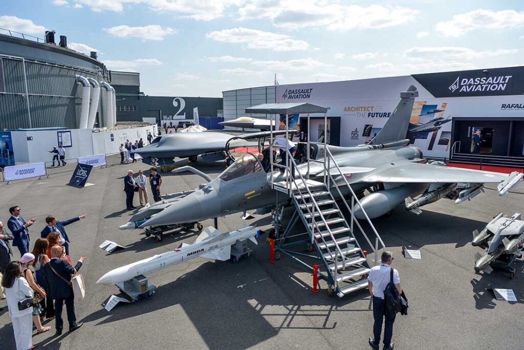 At the Paris Air Show 2025, the NGF mock-up was relocated around the corner from the main Dassault static display, which was dominated by the Rafale (foreground) and a new UCAS (middle) based on the nEUROn demonstrator. The nose of the NGF model (background) can just be seen ‘peeking’ out behind the UCAS model. [Dassault]