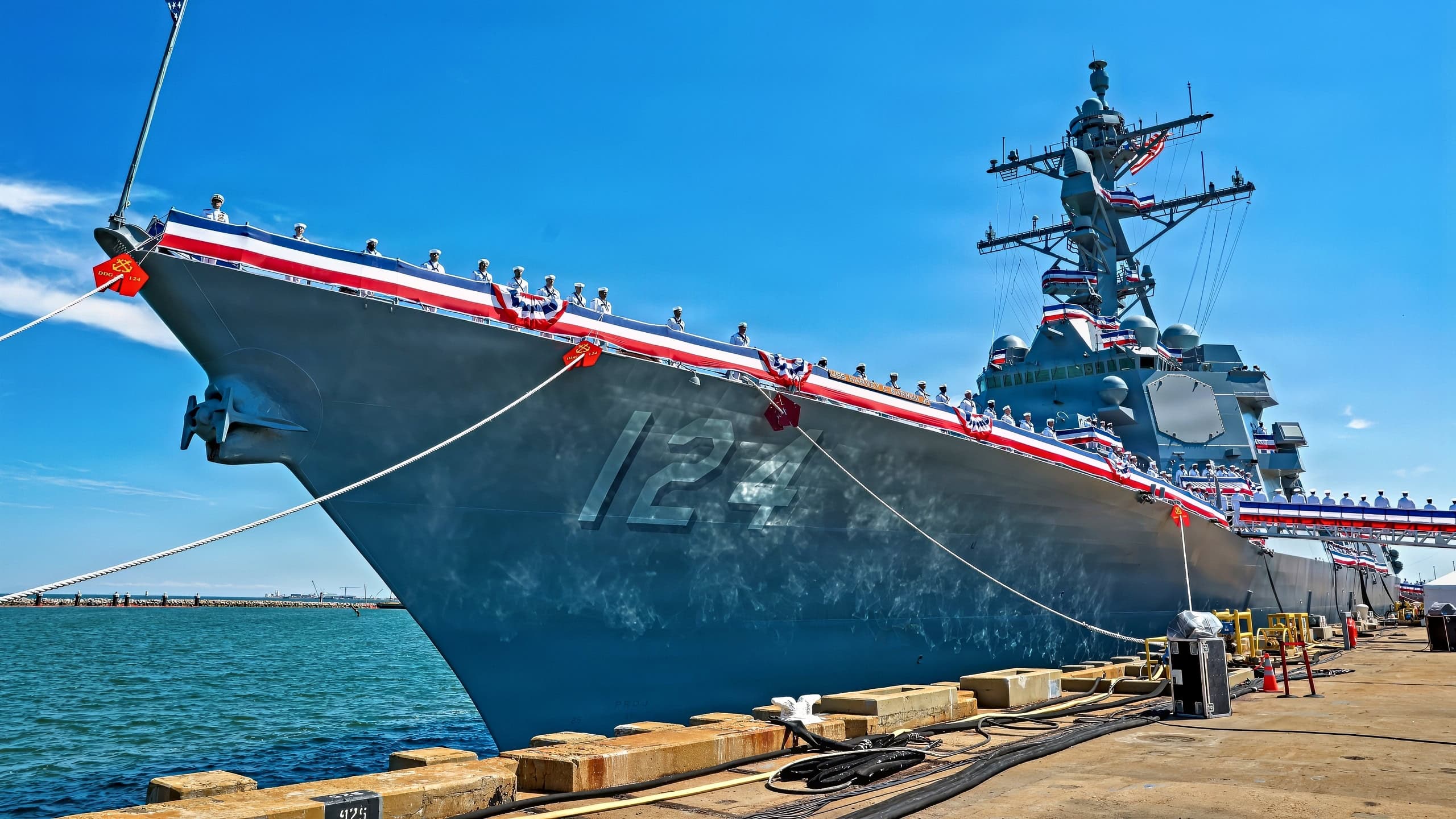 (April 11, 2026) – Sailors man the rails aboard the Navy’s newest Arleigh Burke-class guided-missile destroyer USS Harvey C. Barnum Jr. (DDG 124) during the commissioning ceremony in Norfolk, Virginia, April 11, 2026. The warship bears the name of a living Medal of Honor recipient, retired Col. Harvey C. “Barney” Barnum Jr. (U.S. Navy photo by Mass Communication Specialist 1st Class Theoplis Stewart)