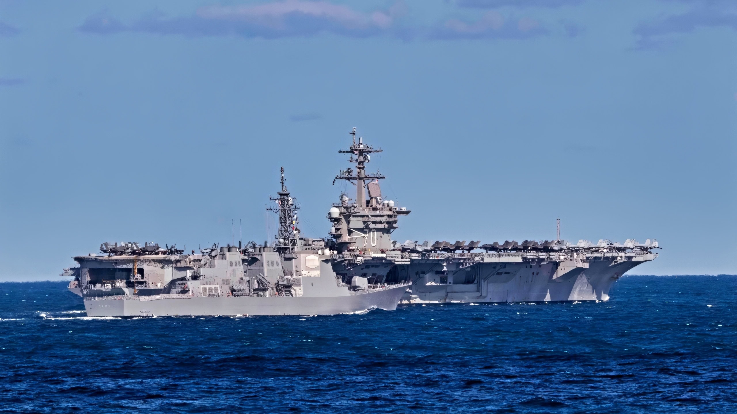 AT SEA (Jan. 16, 2024) The Nimitz class aircraft carrier USS Carl Vinson (CVN 70), back, and the Kongo-class helicopter destroyer JS Kongo (DDG-173) from the Japan Maritime Self Defense Force sail together during a trilateral exercise, Jan. 16. The exercise allowed maritime forces from Japan, Republic of Korea, and U.S. to train together to enhance coordination on maritime domain awareness and other shared security interests. Vinson, flagship of Carrier Strike Group ONE, is deployed to the U.S. 7th Fleet area of operations in support of a free and open Indo-Pacific. (U.S. Navy photo by Mass Communication Specialist 1st Class Charles J. Scudella III)