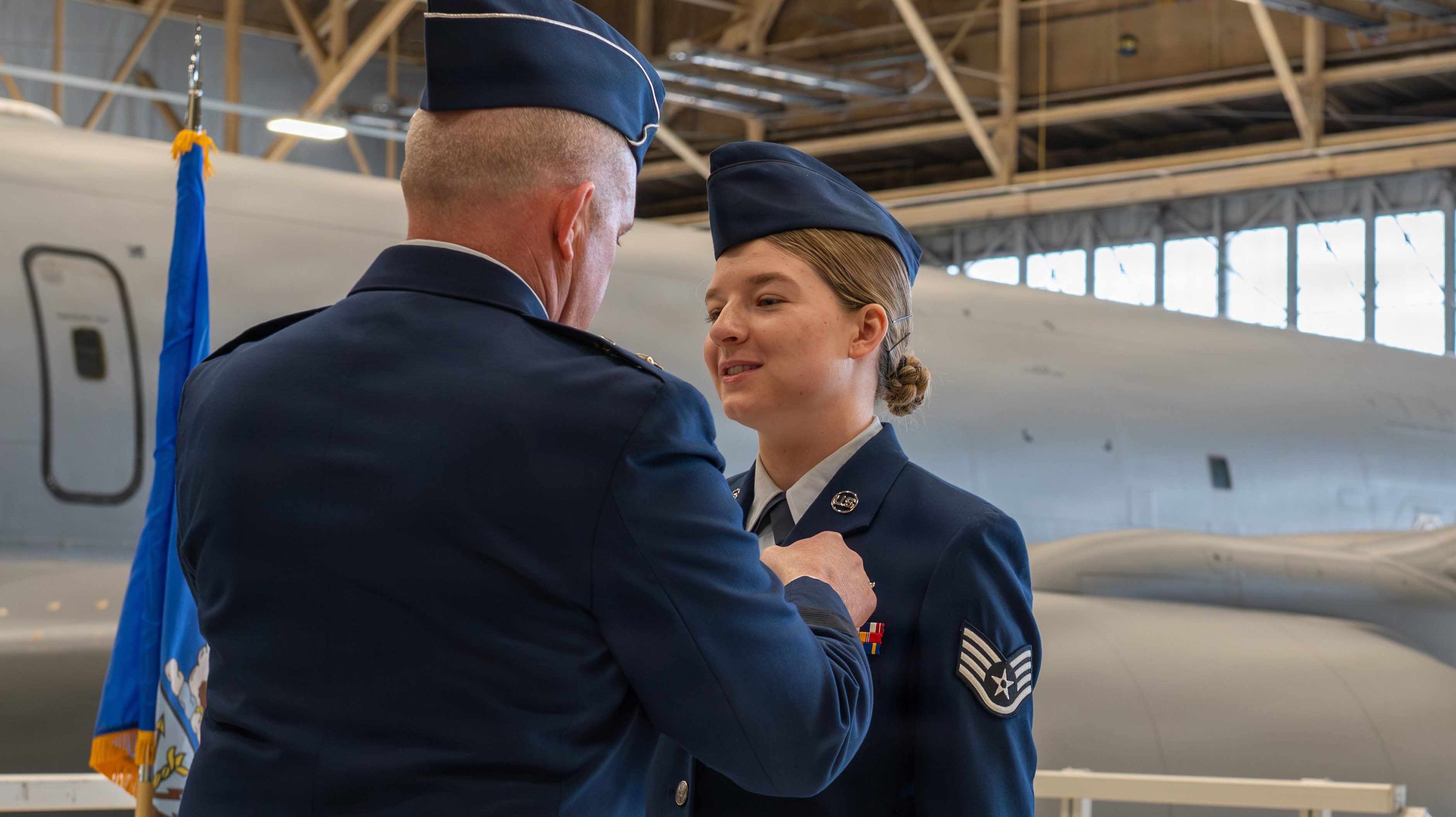 U.S. Air Force Maj. Gen. Charles Bolton, Eighteenth Air Force commander, pins the Distinguished Flying Cross with “C” Device on U.S. Air Force Staff Sgt. Gabrielle Stallings, 93rd Air Refueling Squadron KC-135 Stratotanker boom operator, during a decoration ceremony at Fairchild Air Force Base, Washington, March 31, 2026. This medal is the nation's highest award for extraordinary aerial achievement, with the "C" device signifying meritorious service under combat conditions where the recipient was personally exposed to hostile action. (U.S. Air Force photo by Airman 1st Class Gabriel Conley)