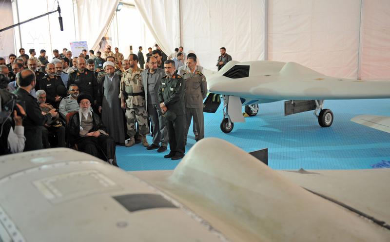 Iran's Supreme Leader Ayatollah Ali Khamenei on May 11, 2014, sits next to a captured U.S. RQ-170 drone that crashed in Iran on December 2011. (AFP via Iranian leader's website)