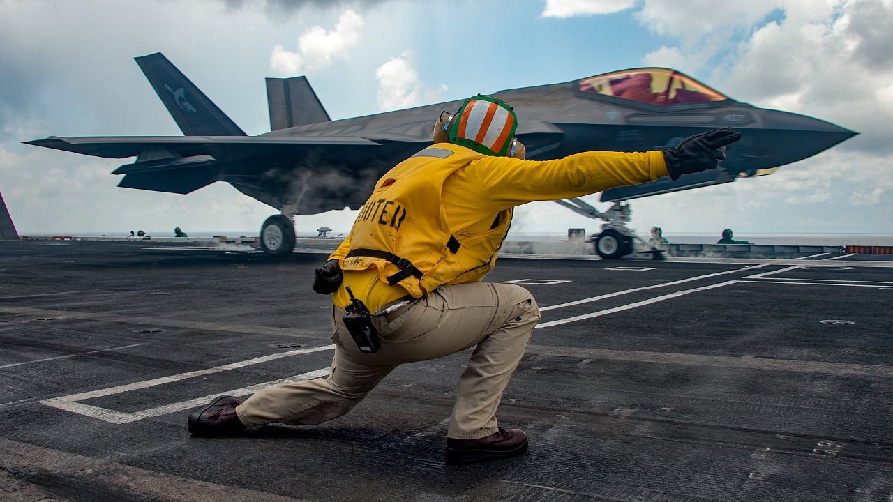 Lt. Nicholas Eppler, from Exeter, Calif., directs flight operations as an F-35C Lightning II assigned to the “Argonauts” of Strike Fighter Squadron (VFA) 147 launches from the Nimitz-class aircraft carrier USS Carl Vinson (CVN 70), Oct. 25, 2021. The Carl Vinson Carrier Strike Group is on a scheduled deployment in the U.S. 7th Fleet area of operations to enhance interoperability through alliances and partnerships while serving as a ready-response force in support of a free and open Indo-Pacific region.