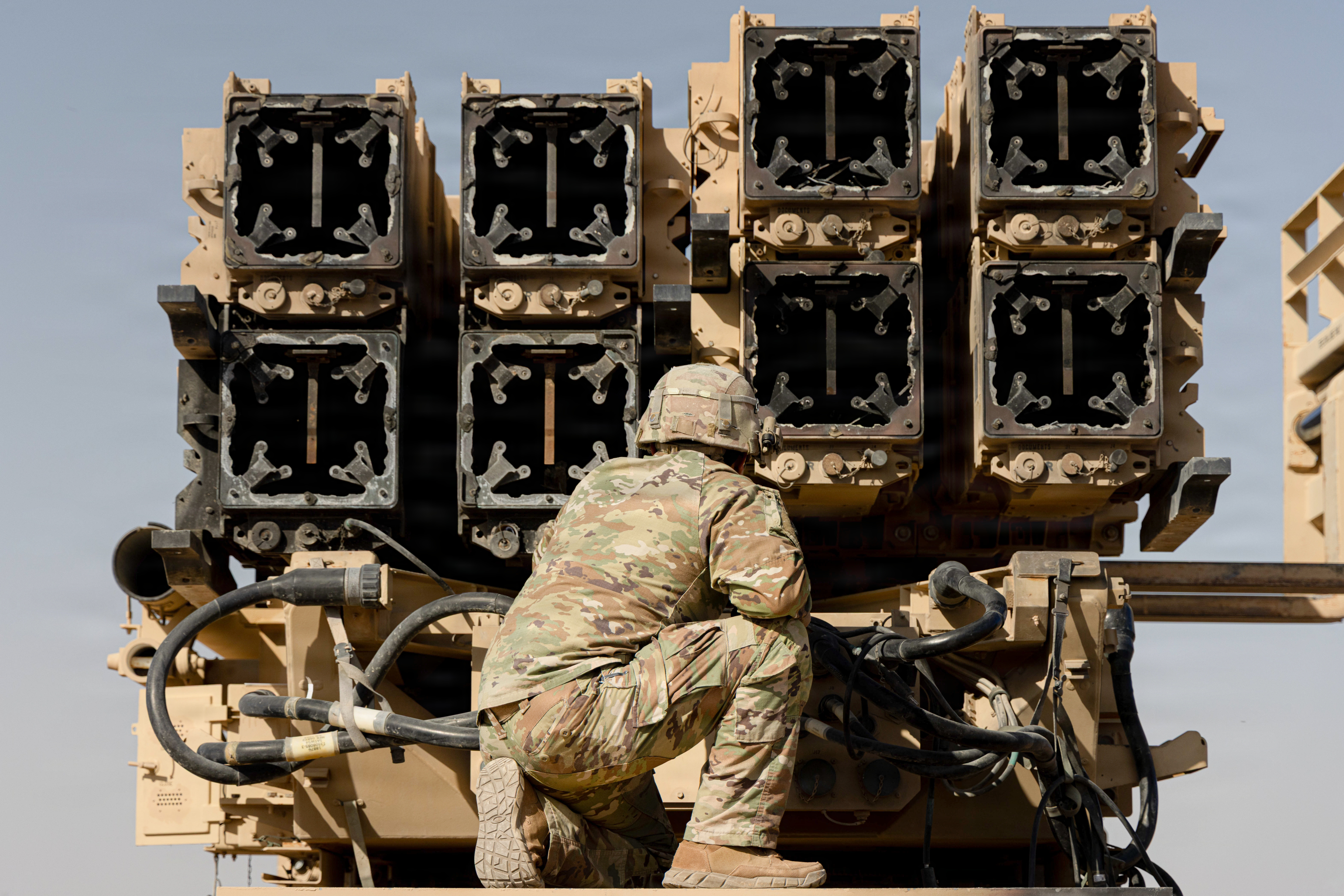 A U.S. Army air defense artilleryman watches as spent Patriot interceptors are cross-loaded for transport in the Middle East. (U.S. Army)
