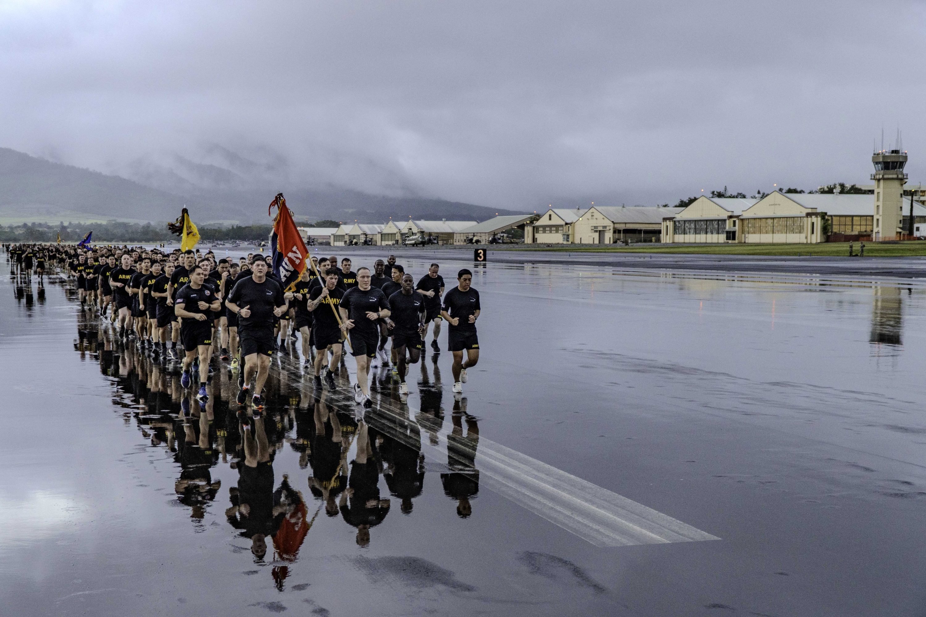 25th Combat Aviation Brigade Soldiers run past the hangars and helicopters on the flight line during a brigade run on Wheeler Army Airfield, Hawaii, March 10, 2025. The 25th CAB leadership lead the formation on the run. (U.S. Army photo by Spc. Charles Clark)