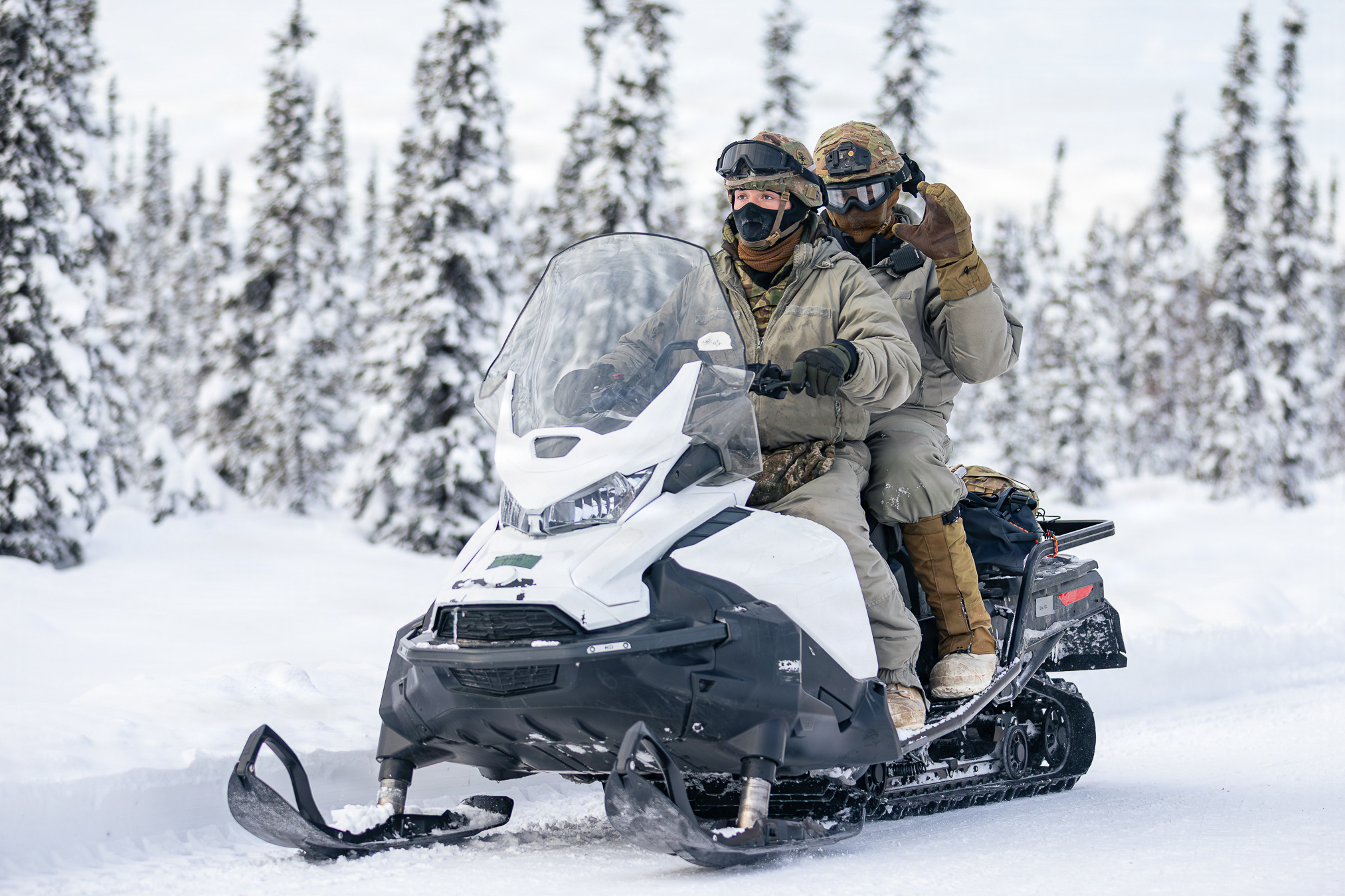 Two service members operate a snowmachine in the Yukon Training Area. (Spc. Cole Moore/U.S. Army)