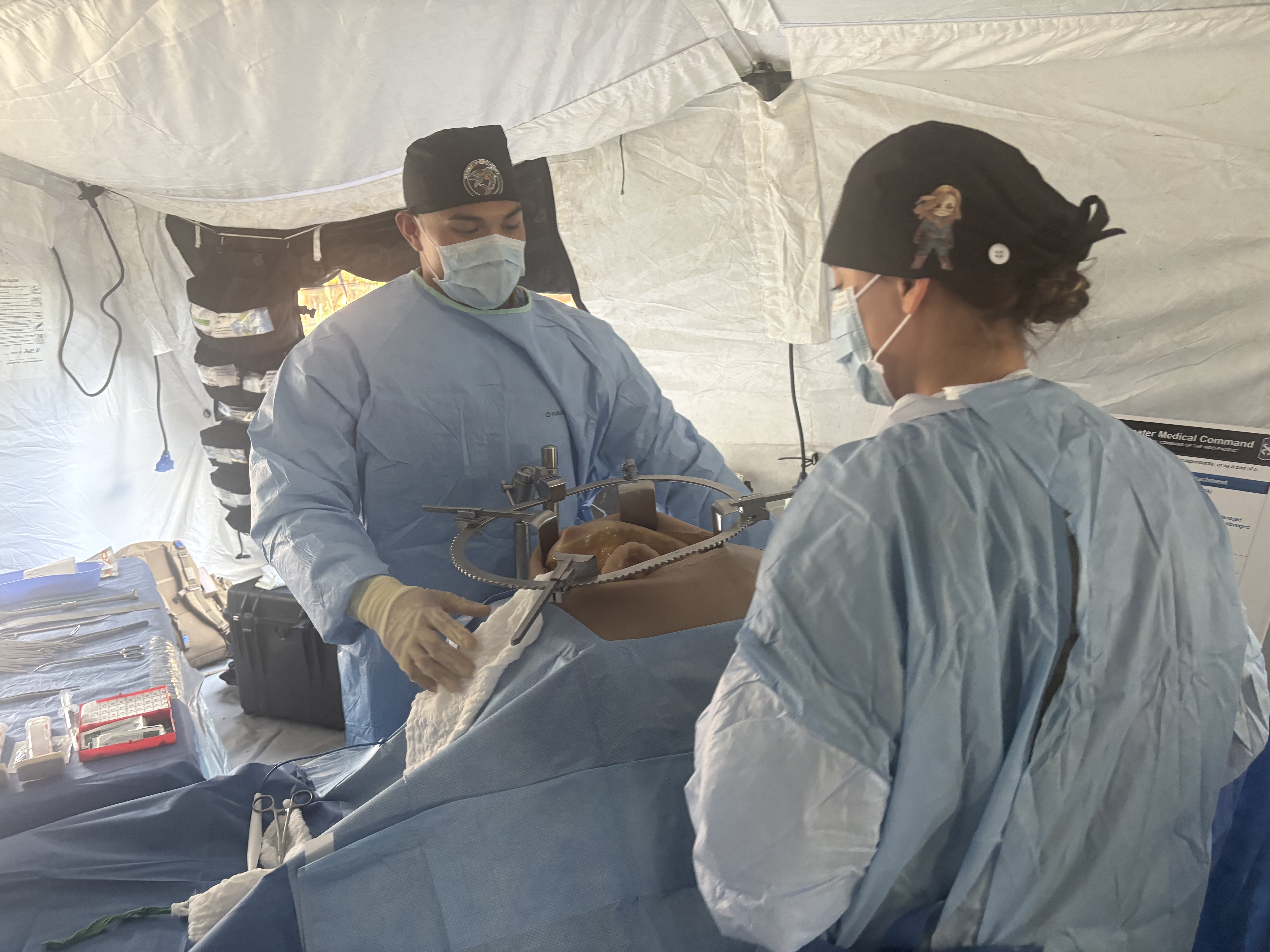Combat medics operate on a mock patient in a Forward Resuscitative Surgical Detachment tent during a demonstration at LANPAC on May 13, 2026. (Military Times)