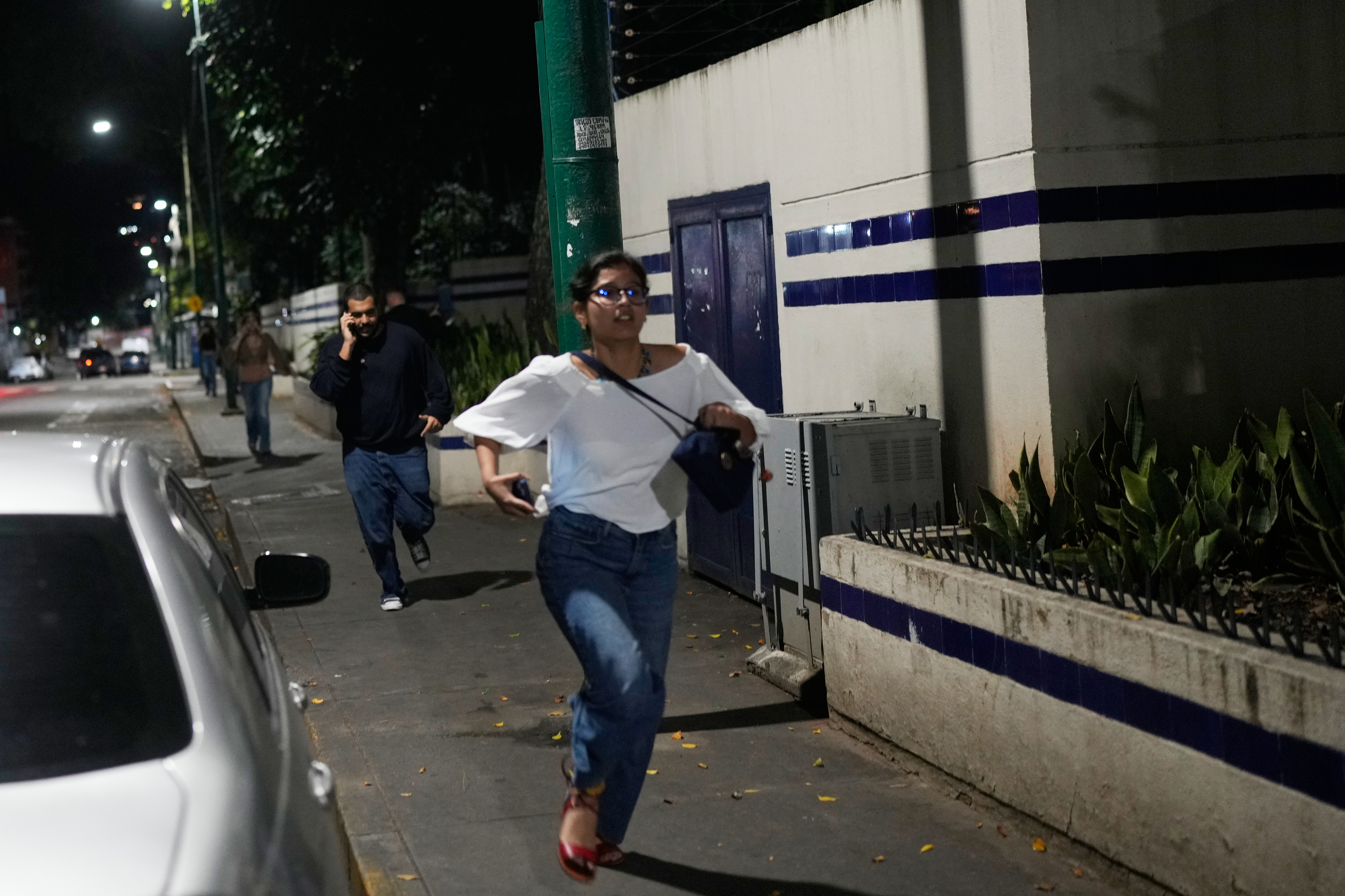 Pedestrians run after explosions and low-flying aircraft were heard in Caracas, Venezuela, Jan. 3, 2026. (Matias Delacroix/AP)