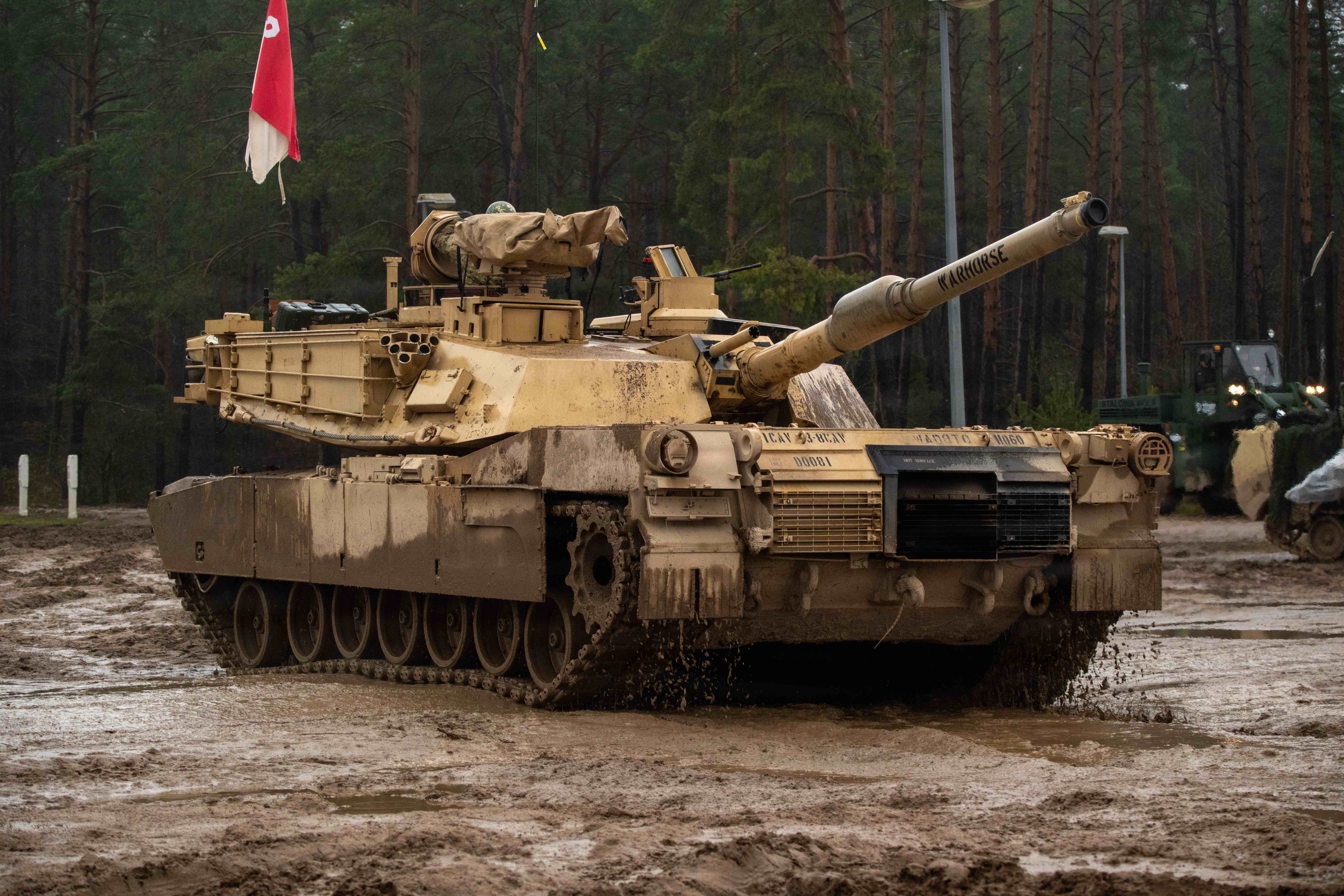 An M1A2 Abrams tank assigned to 3rd Battalion, 8th Cavalry Regiment maneuvers through heavy mud while returning from a static display at Bemowo Piskie Training Area, Poland, Dec. 10, 2025. Despite slick and uneven terrain, crews demonstrated the vehicle’s mobility and reliability during Table V gunnery operations. The task force provides combat credible forces to V Corps, America's only forward-deployed corps in Europe.