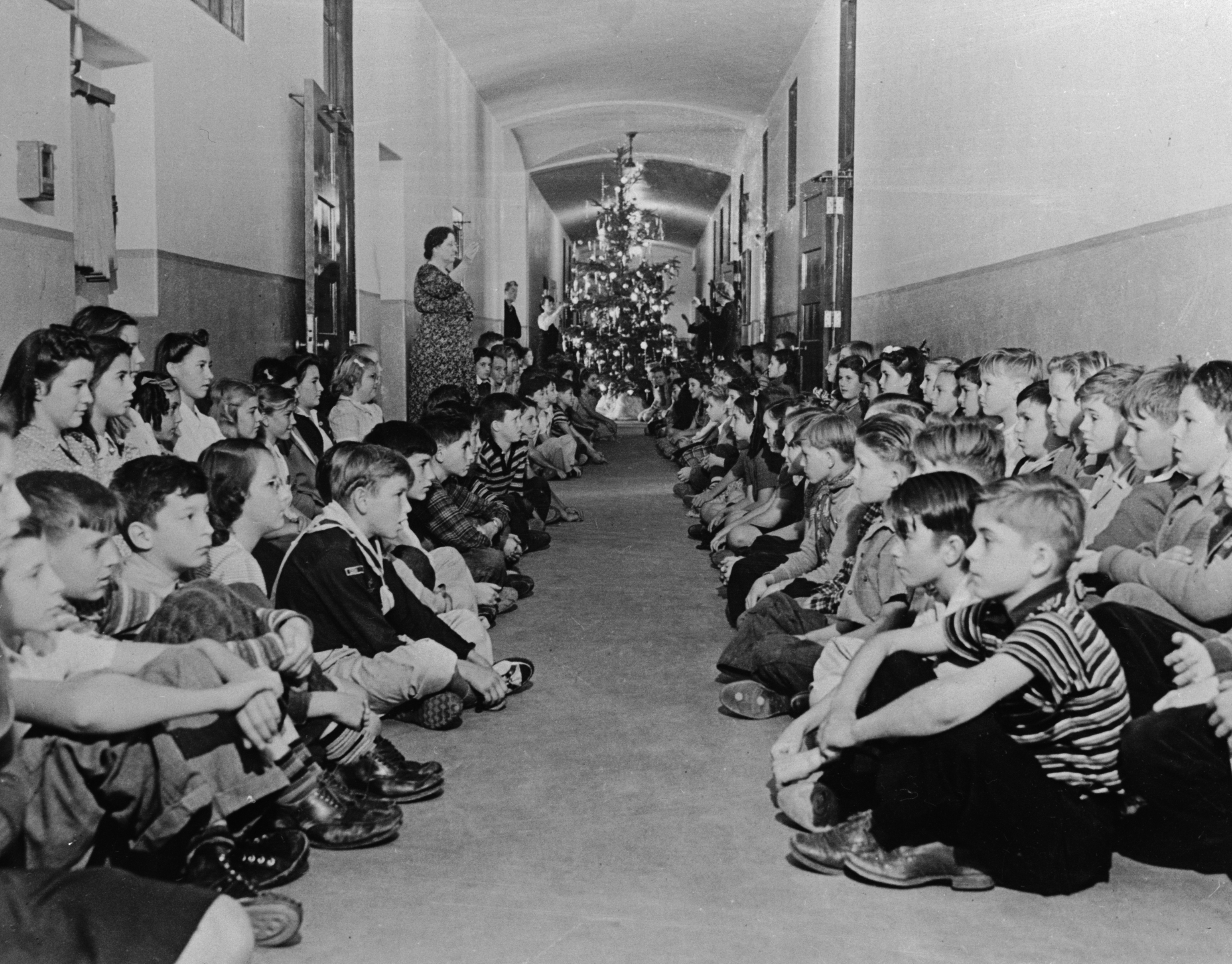 School children in Los Angeles practice an air raid drill in one of the school's main halls, with a Christmas tree staged, December 1941. (Bettmann Archive/Getty Images)