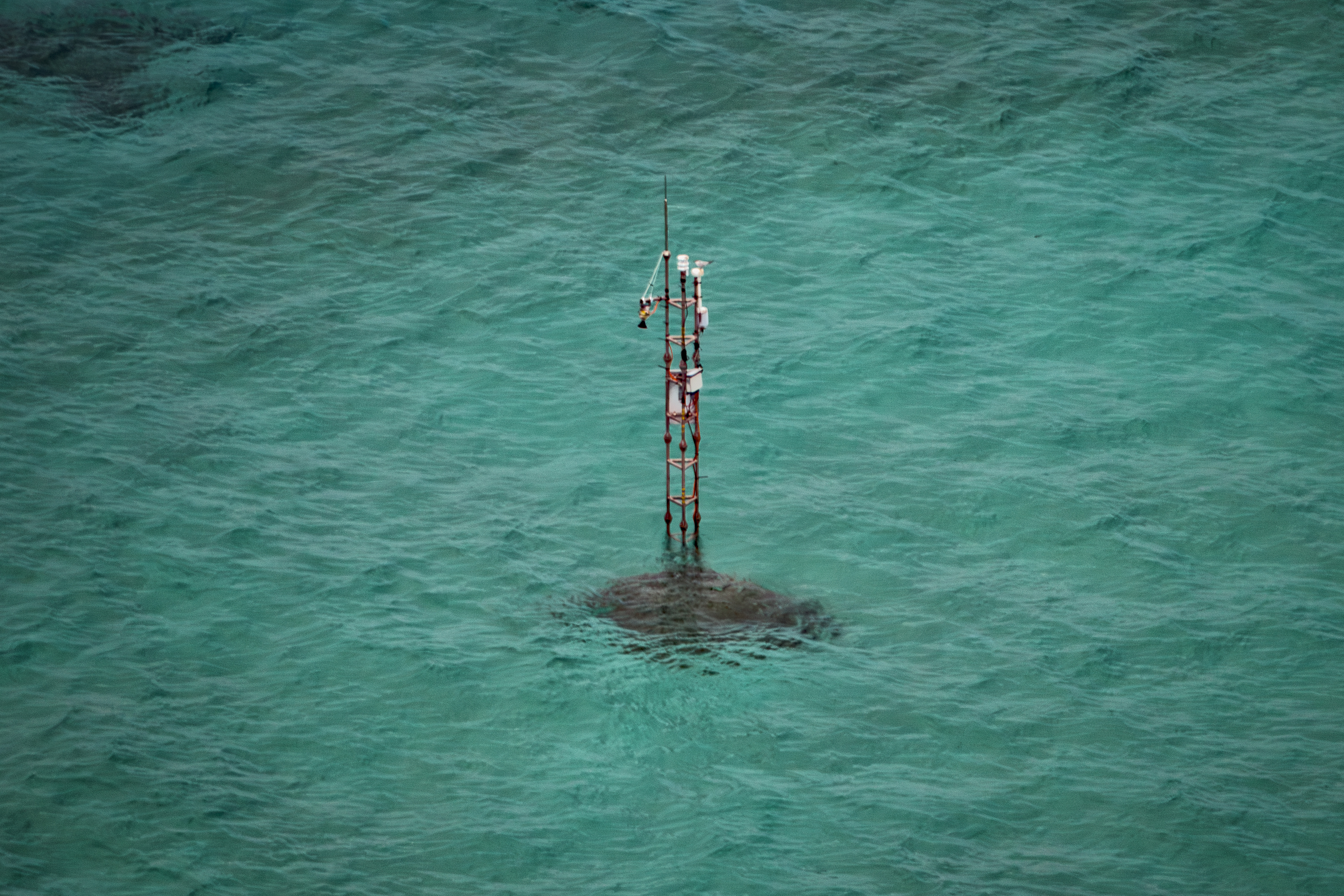 An antenna structure, which the Philippine Coast Guard says was placed there by China, is seen from aboard a Philippine Bureau of Fisheries and Aquatic Resources (BFAR) plane on June 15, 2026, in Scarborough Shoal, South China Sea. (Ezra Acayan/Getty Images)