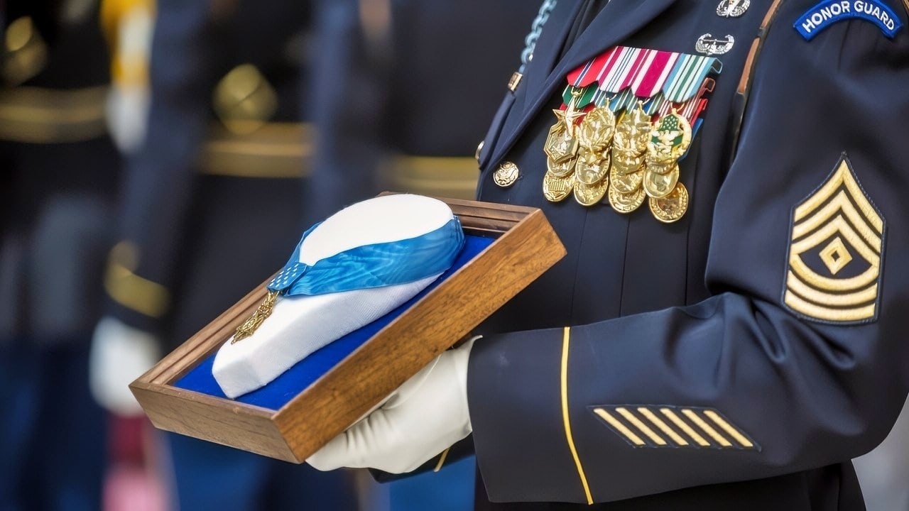 U.S. Army 1st. Sgt. Robert Durbin holds 1st Sgt. David McNerney's Medal of Honor during an Enshrinement Ceremony at the Smithsonian National Postal Museum in Washington, D.C., on Sept. 22, 2013. The Smithsonian Institution accepted McNerney's Medal of Honor for inclusion in the National Postal Museum collection where it will be displayed in the National Stamp Salon of the William H. Gross Stamp Gallery. (DoD photo by Staff Sgt. Teddy Wade, U.S. Army/Released)