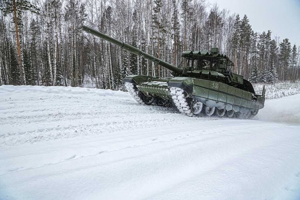 A T-72B3A at UVZ’s trials site. The new modification features a combination of Kontakt-1, Kontakt-5 and Relikt ERA, electronic warfare jammers, anti-drone protection measures such as overhead protection, netting and rubber-polymer screens, along with an upgraded version of the Arena-M APS. [UVZ]
