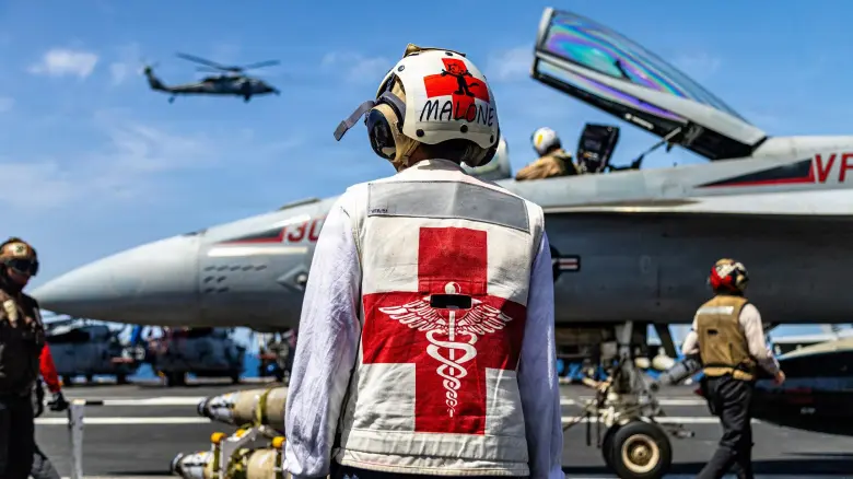 A U.S. sailor, assigned to Strike Fighter Squadron 31, serves as a medical safety observer on the flight deck of the USS Gerald R. Ford on March 17, 2026, during Operation Epic Fury. (U.S. Navy photo)