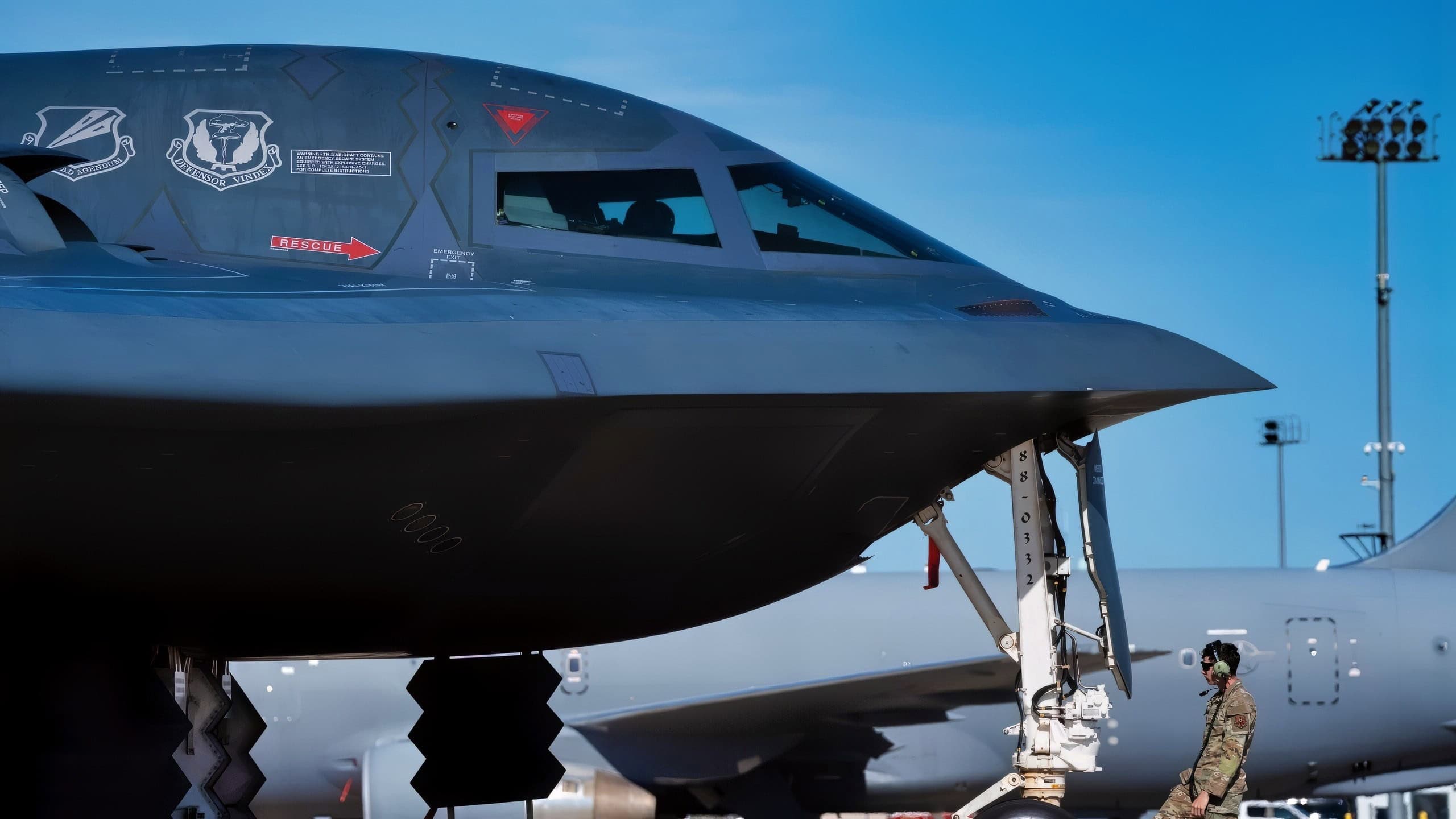 U.S. Air Force Staff Sgt. Hunter Kaloci, 393rd Bomber Generation Squadron crew chief, adjusts a wheel chock in front of a parked B-2 Spirit aircraft at Pease Air National Guard Base, New Hampshire, Sept. 20, 2025. The 393rd BGS provides worldwide combat capability by planning and conducting all aspects of on-aircraft maintenance, launch and recovery of B-2 aircraft in direct support of Joint Chiefs of Staff nuclear and conventional taskings. (U.S. Air Force photo by Staff Sgt. Joshua Hastings)