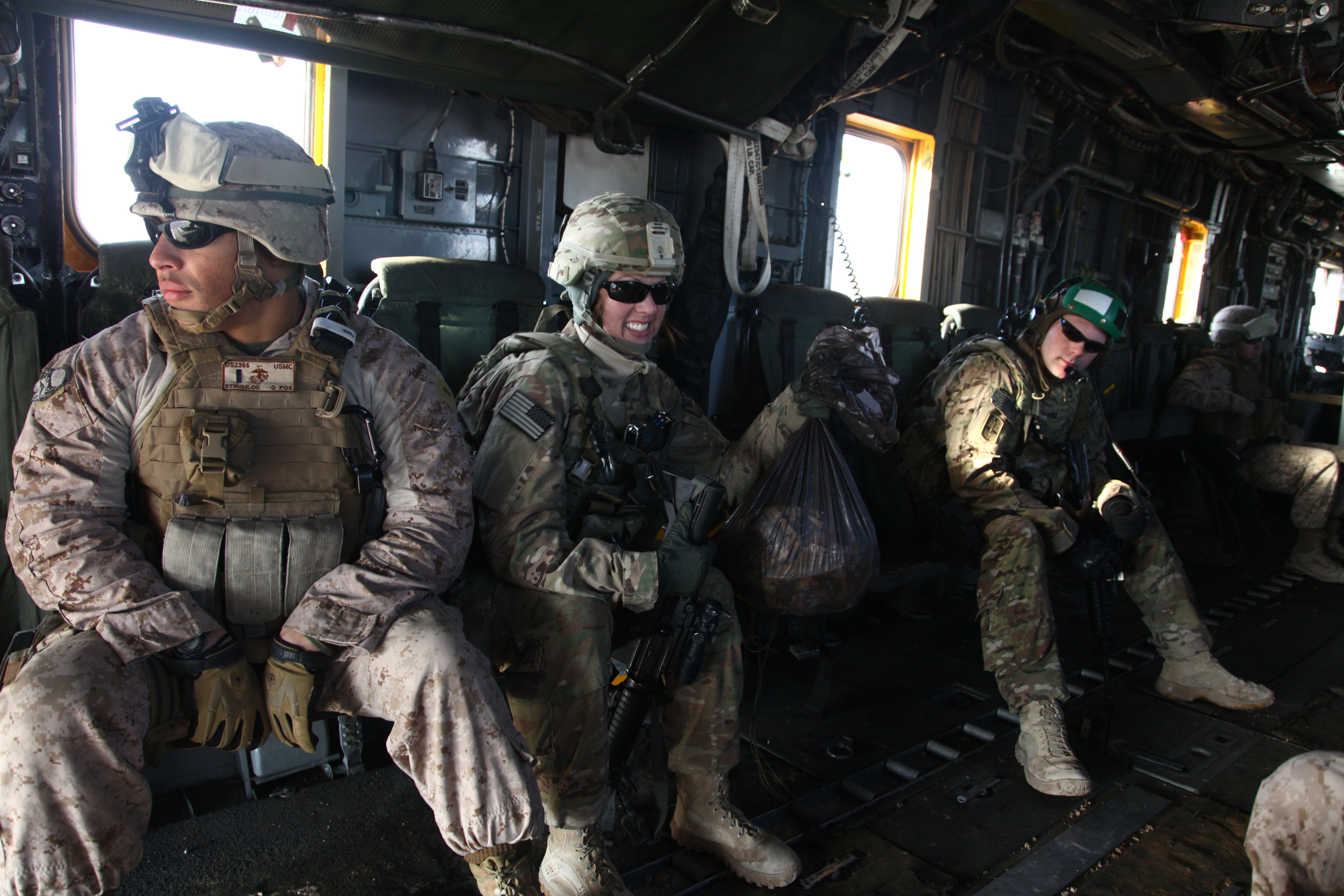 U.S. Army Cpl. Christina Larson, second from left, prepares leaflets to drop over Helmand province, Afghanistan, Feb. 22, 2012. The leaflet drop was in support of an operation to disrupt insurgent forces in the area to further degrade the distribution of narcotics, weapons, improvised explosive devices and IED material. (U.S. Marine Corps photo by Lance Cpl. Catie Edwards/Released)