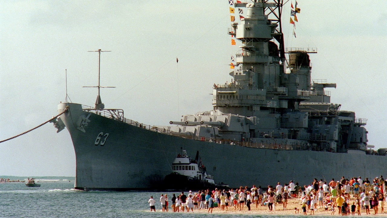 人们聚集在海滩上观看战列舰密苏里号（BB 63）于1998年6月22日进入夏威夷珍珠港的航道。海军部长约翰·H·达尔顿于5月4日签署了捐赠协议，允许密苏里号作为亚利桑那纪念馆附近的博物馆使用。这艘船是从华盛顿州布雷默顿拖来的。国防部照片由美国海军一等水手大卫·韦德曼提供。