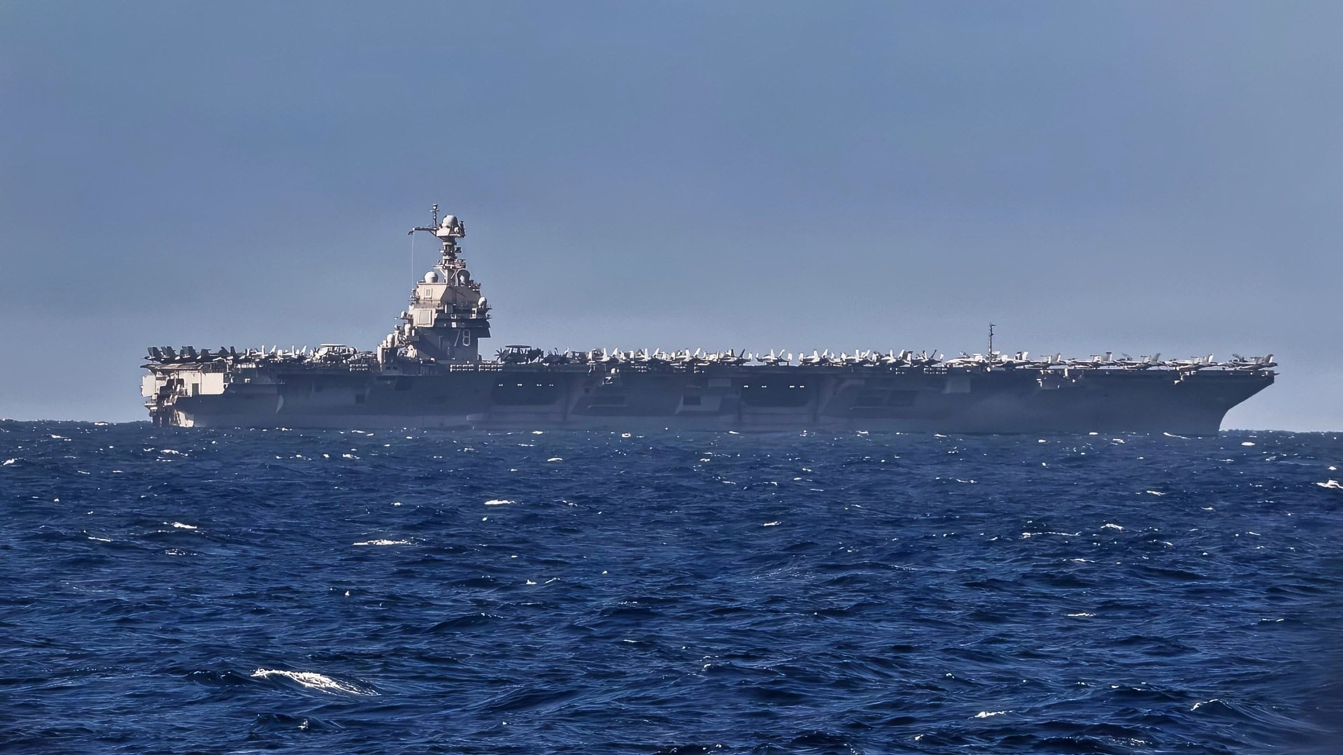 The world’s largest aircraft carrier, USS Gerald R. Ford, as seen from Arleigh Burke-class guided missile destroyer USS Bainbridge (DDG 96) before a replenishment-at-sea with Henry J. Kaiser-class fleet replenishment oiler USNS Kanawha (T-AO 196) while underway during Operation Epic Fury, Mar. 8, 2026. (U.S. Navy Photo)