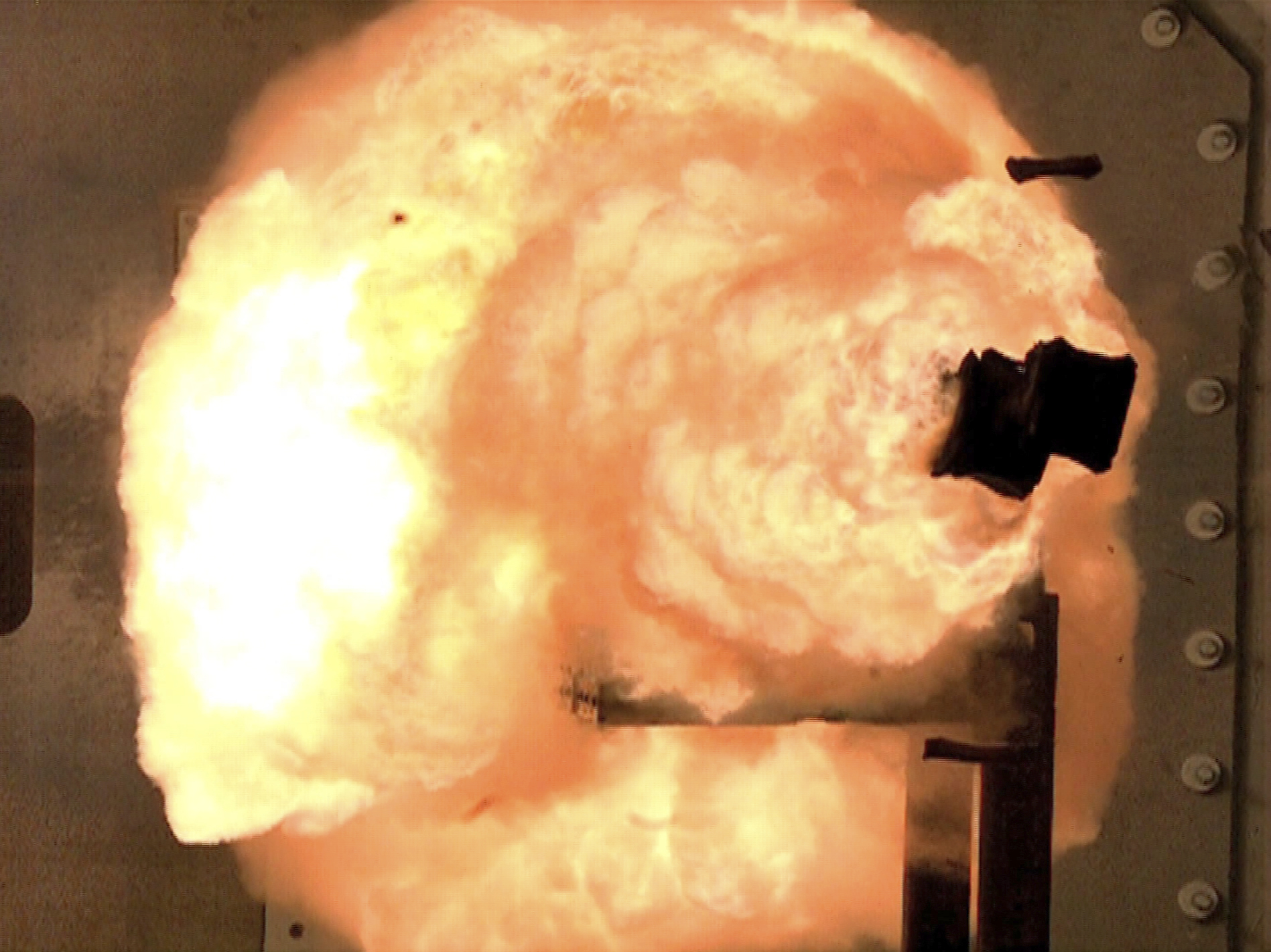 A high-speed camera captures a full-energy shot by an electromagnetic railgun prototype launcher. (John F. Williams/U.S. Navy)