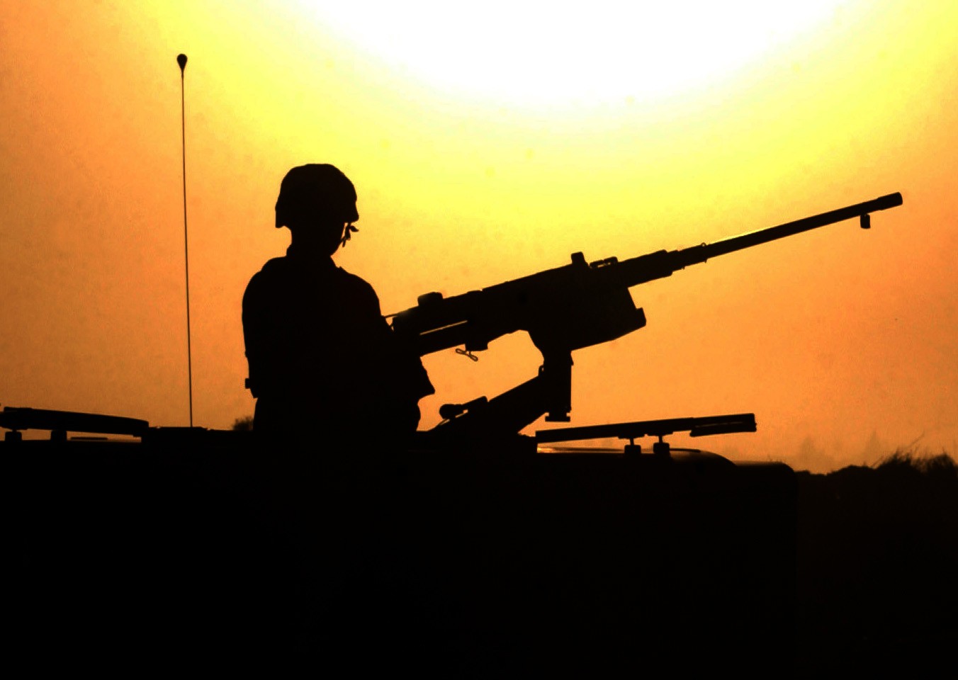 A soldier provides security with a .50-caliber machine gun at a site near Balad, Iraq, October 14, 2003. (Army)