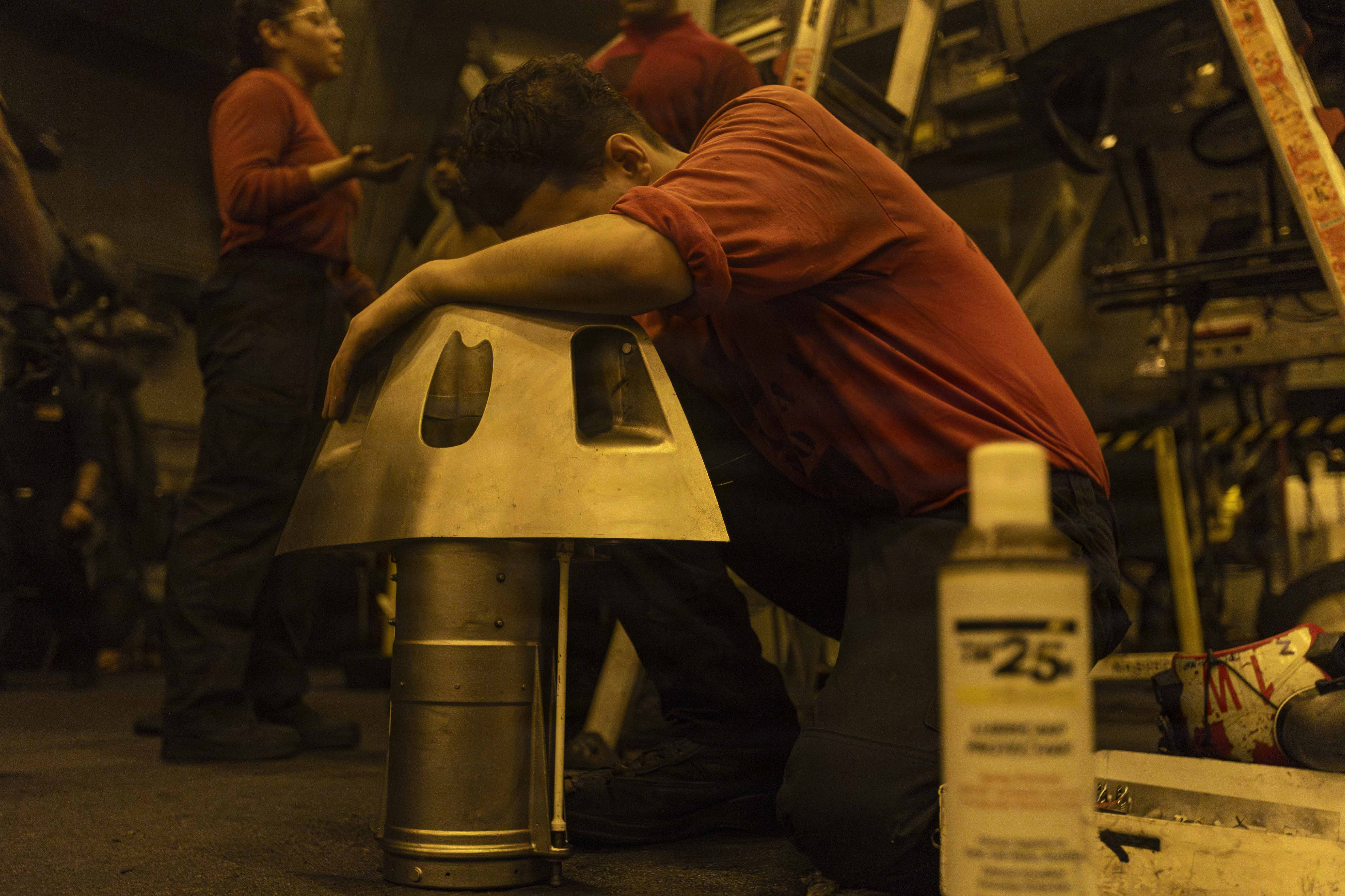 A sailor works on an aircraft component in the hangar bay of Nimitz-class aircraft carrier USS Abraham Lincoln on Aug. 11, 2026. (U.S. Navy)