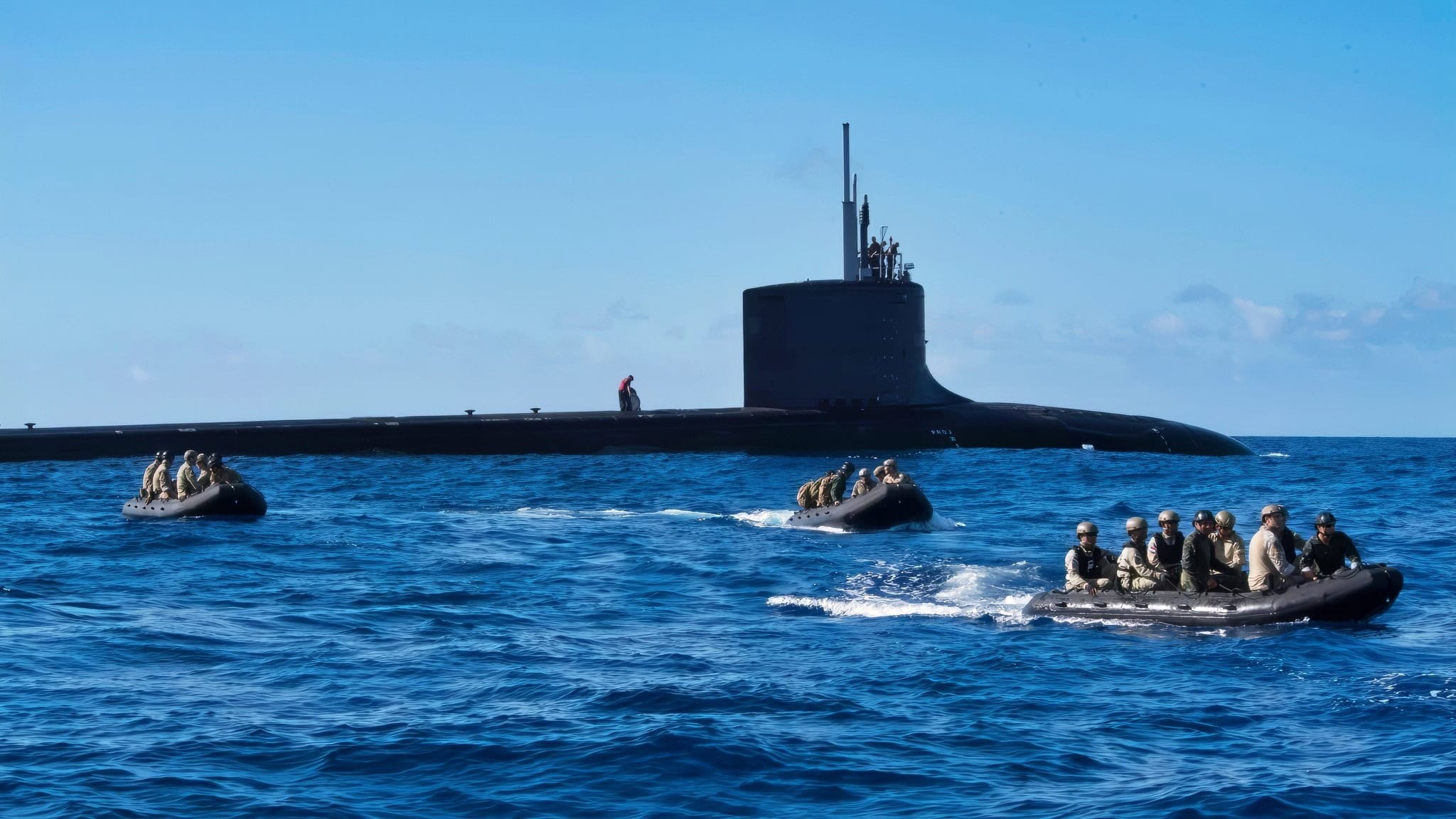 珍珠港（2018年7月9日）——多国特种作战部队（SOF）与快速攻击潜艇USS Hawaii（SSN 776）和战斗橡皮艇在夏威夷欧胡岛海岸进行潜艇插入演习，时间为7月9日。在6月27日至8月2日期间，来自25个国家的46艘舰艇和5艘潜艇、约200架飞机和25,000名人员参与了在夏威夷群岛和南加州周边进行的环太平洋（RIMPAC）演习。作为世界上最大的国际海上演习，RIMPAC提供了独特的训练机会，同时促进和维持参与者之间的合作关系，这对确保海上航道的安全和世界海洋的安全至关重要。RIMPAC 2018是自1971年开始的系列演习中的第26次。（美国海军照片，由中尉Michelle Pelissero拍摄）