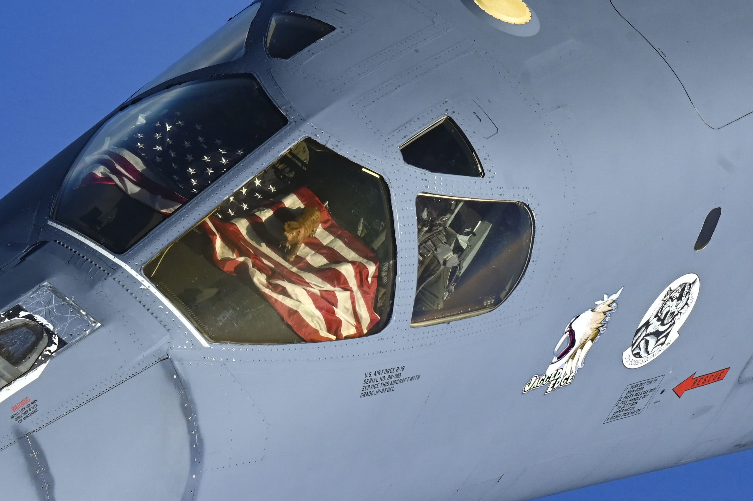 The crew of a U.S. Air Force B-1B Lancer display their mascot from the cockpit window during a presence patrol above the U.S. Central Command’s area of responsibility Oct. 30, 2021. Multiple partner nations’ fighter aircraft accompanied the B-1B Lancer at different points during the flight, which flew over the Gulf of Aden, Bab el-Mandeb Strait, Red Sea, Suez Canal, Arabian Gulf, Strait of Hormuz and the Gulf of Oman before departing the region. (U.S. Air Force photo by Senior Airman Jerreht Harris)