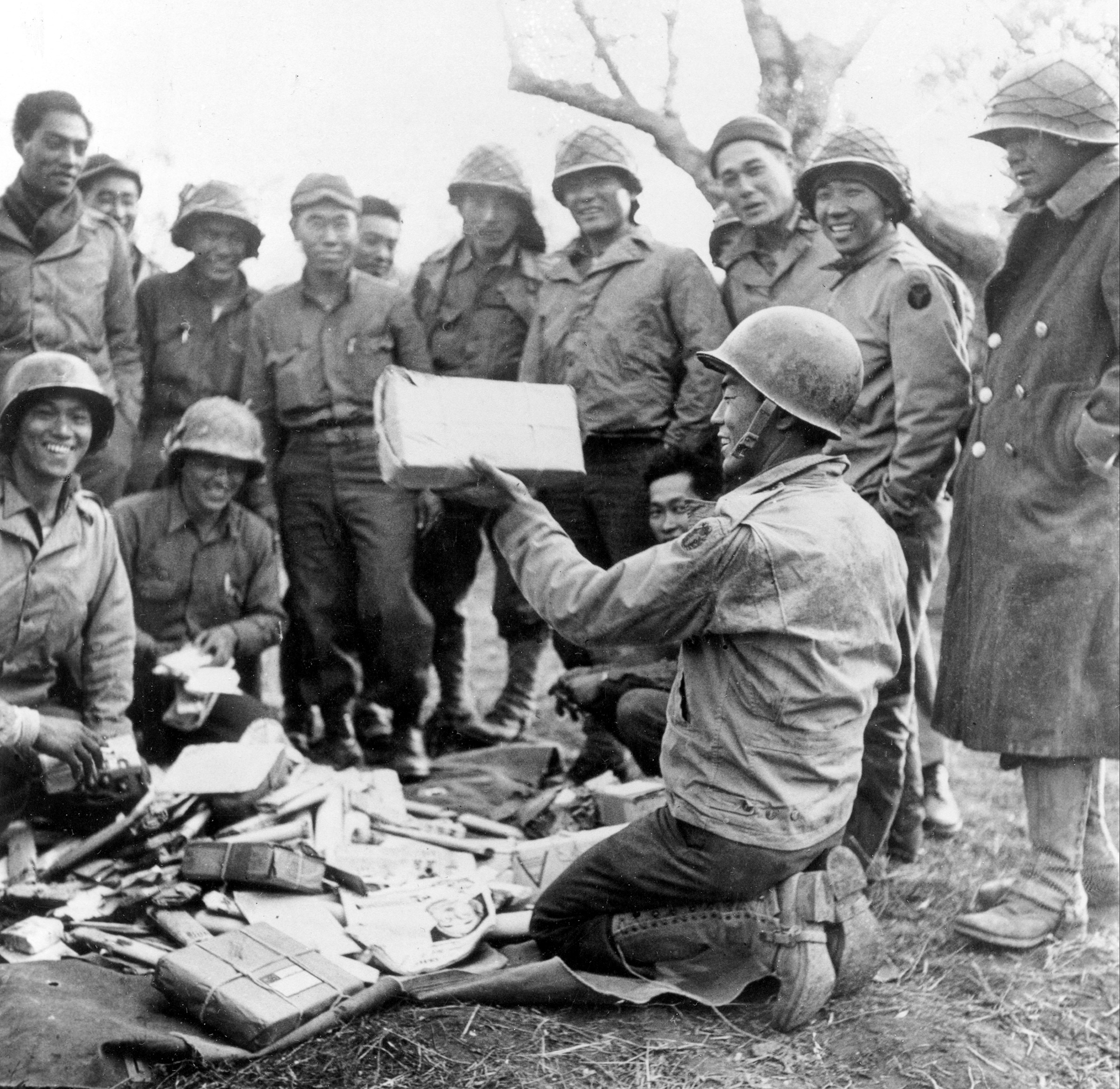 Japanese-Americans fighting with Allies in Italy open Christmas packages sent from home at a bivouac behind the lines in 1943 during WWII.  (AP)