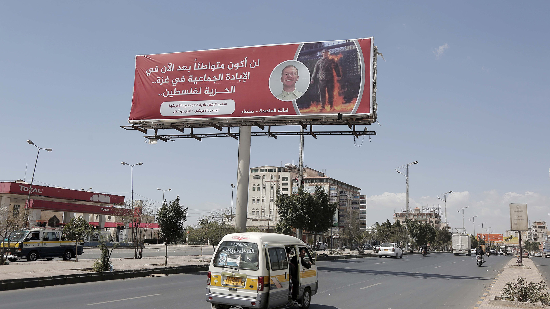 SANAA, YEMEN - MARCH 04: A billboard with a banner displaying the picture of Aaron Bushnell, the US Air Force soldier who set himself on fire, saying that he would not be a partner in the genocide in Gaza with the phrase 'Martyr for Refusing the American Genocide' is seen by a road in Sana'a, Yemen on March 04, 2024. (Photo by Mohammed Hamoud/Anadolu via Getty Images)